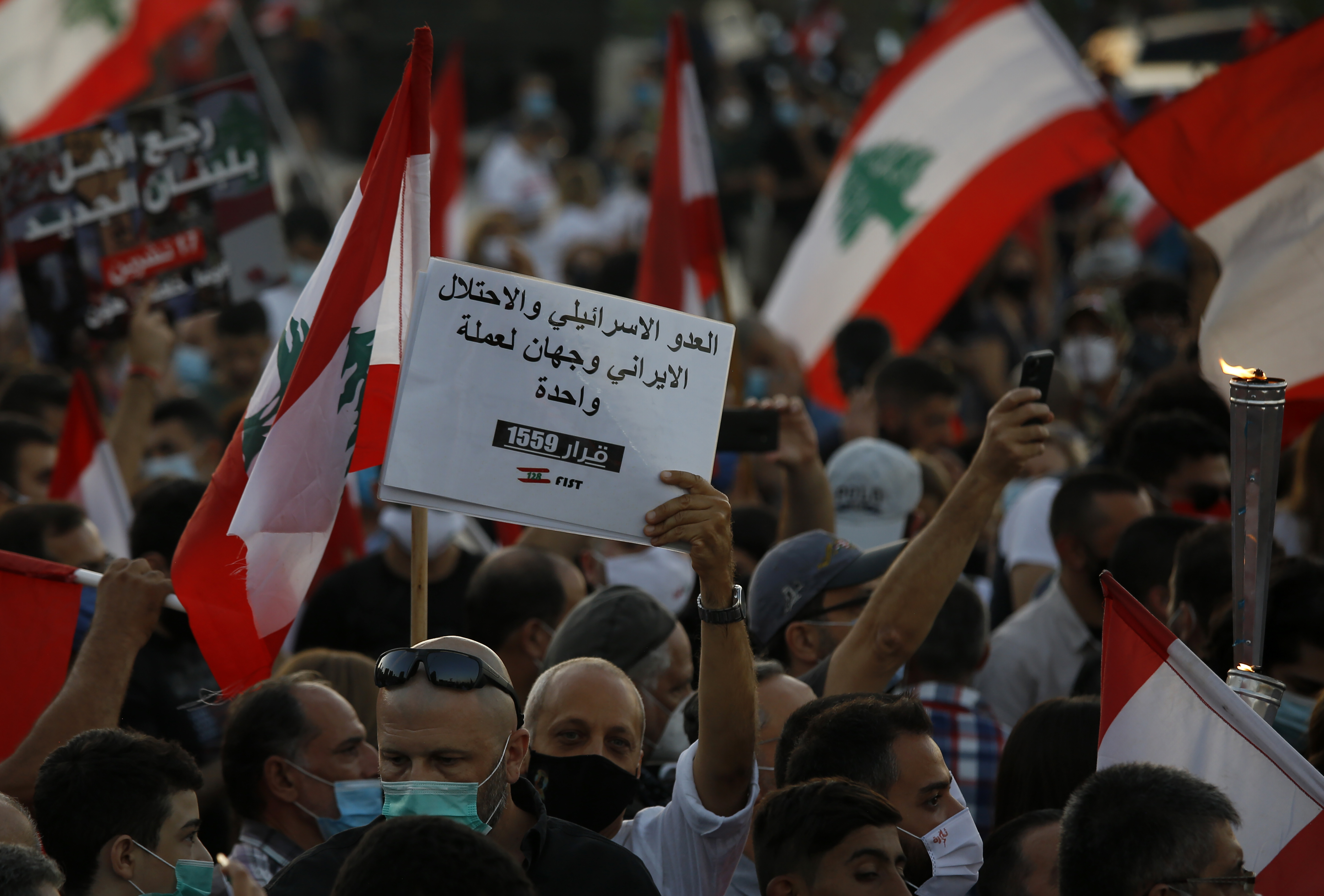 Anti-government protesters march in Beirut to mark the first anniversary of protest movement