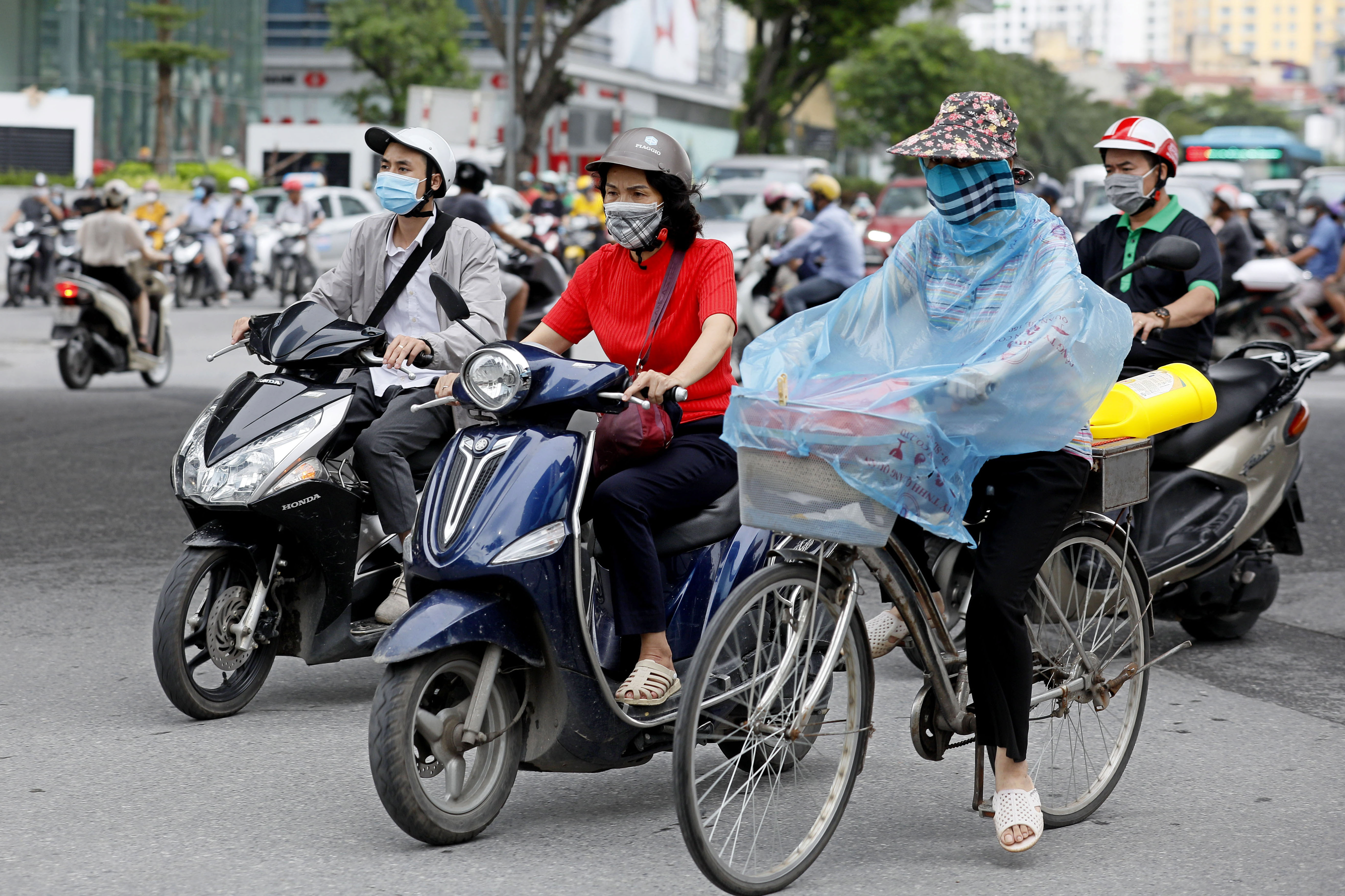 epa08587161 People wearing face masks ride in a street of Hanoi, Vietnam, 06 August 2020. Vietnam has recently seen an uptick in coronavirus cases after being free of domestically transmitted infections for 100 days.  EPA-EFE/LUONG THAI LINH