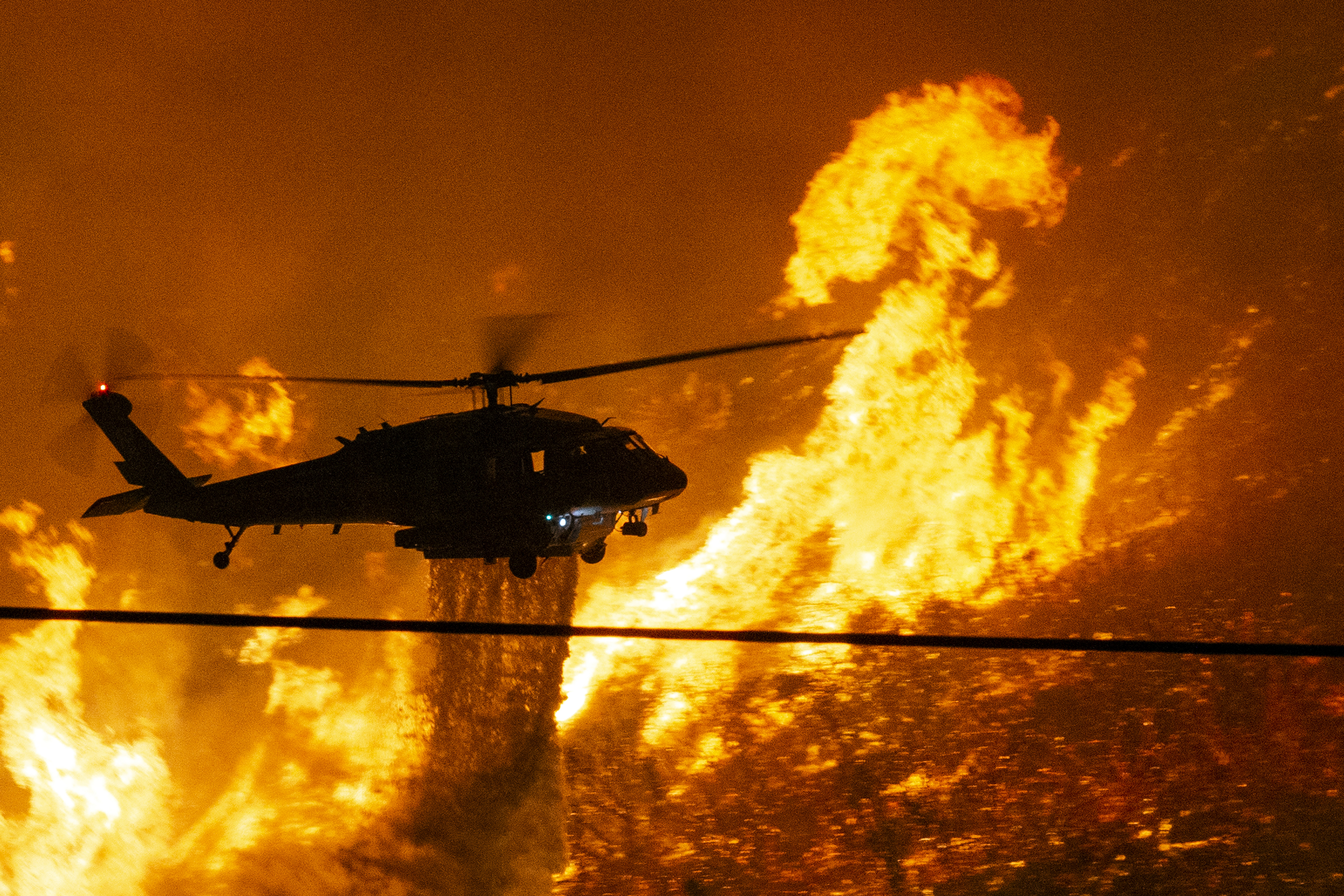 epa08600373 A firefighter helicopter drops water on the Lake Fire as it continues its progress in Lake Hughes, California, USA, 12 August 2020. According to the latest media report the fire burnt 10,000 acres.  EPA-EFE/ETIENNE LAURENT
