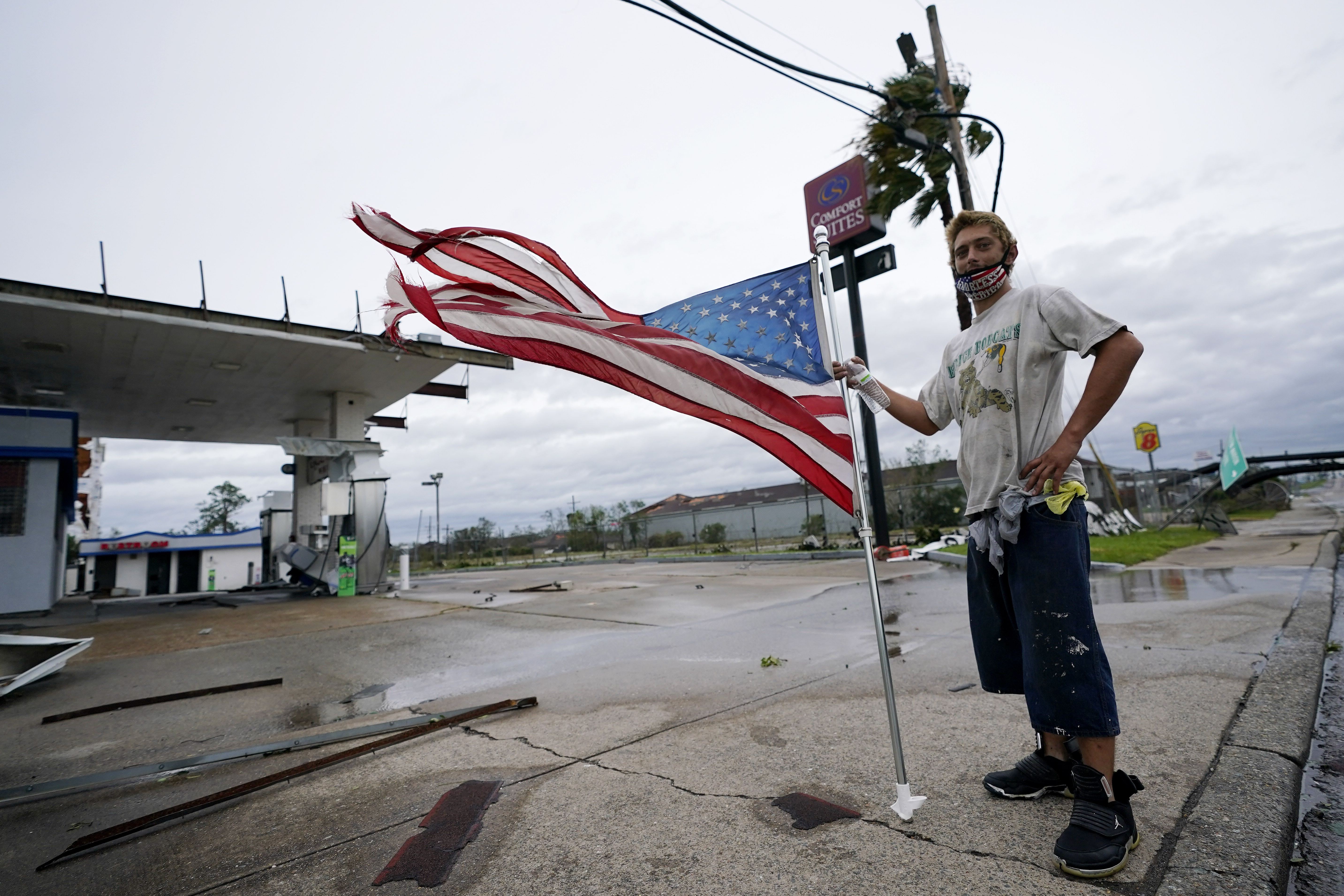 Dustin Amos walks near debris at a gas station on Thursday, Aug. 27, 2020, in Lake Charles, La., after Hurricane Laura moved through the state. (AP Photo/Gerald Herbert)