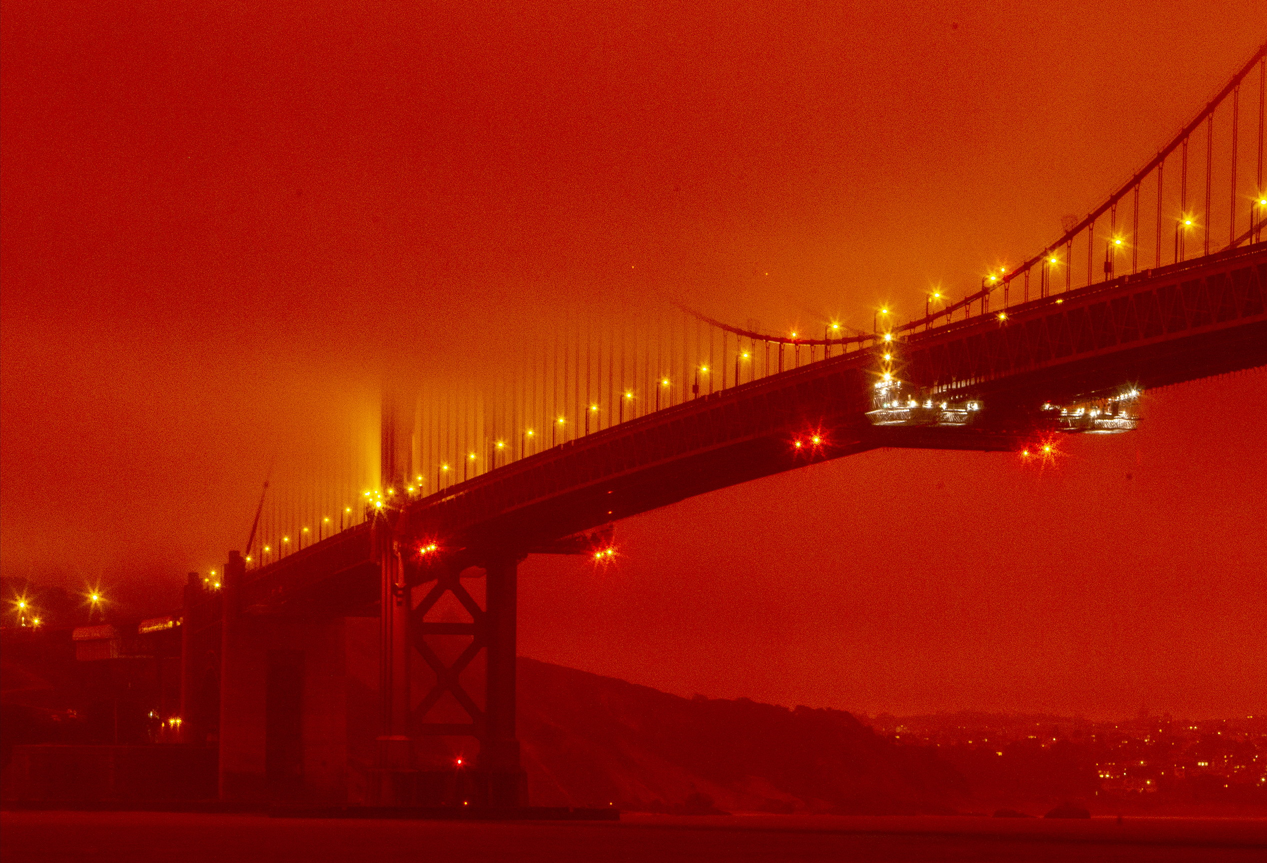 In this photo provided by Frederic Larson, the Golden Gate Bridge is seen at 11 a.m. PT amid a smoky, orange hue caused by the ongoing wildfires, Wednesday, Sept. 9, 2020, in San Francisco. (Frederic Larson via AP)