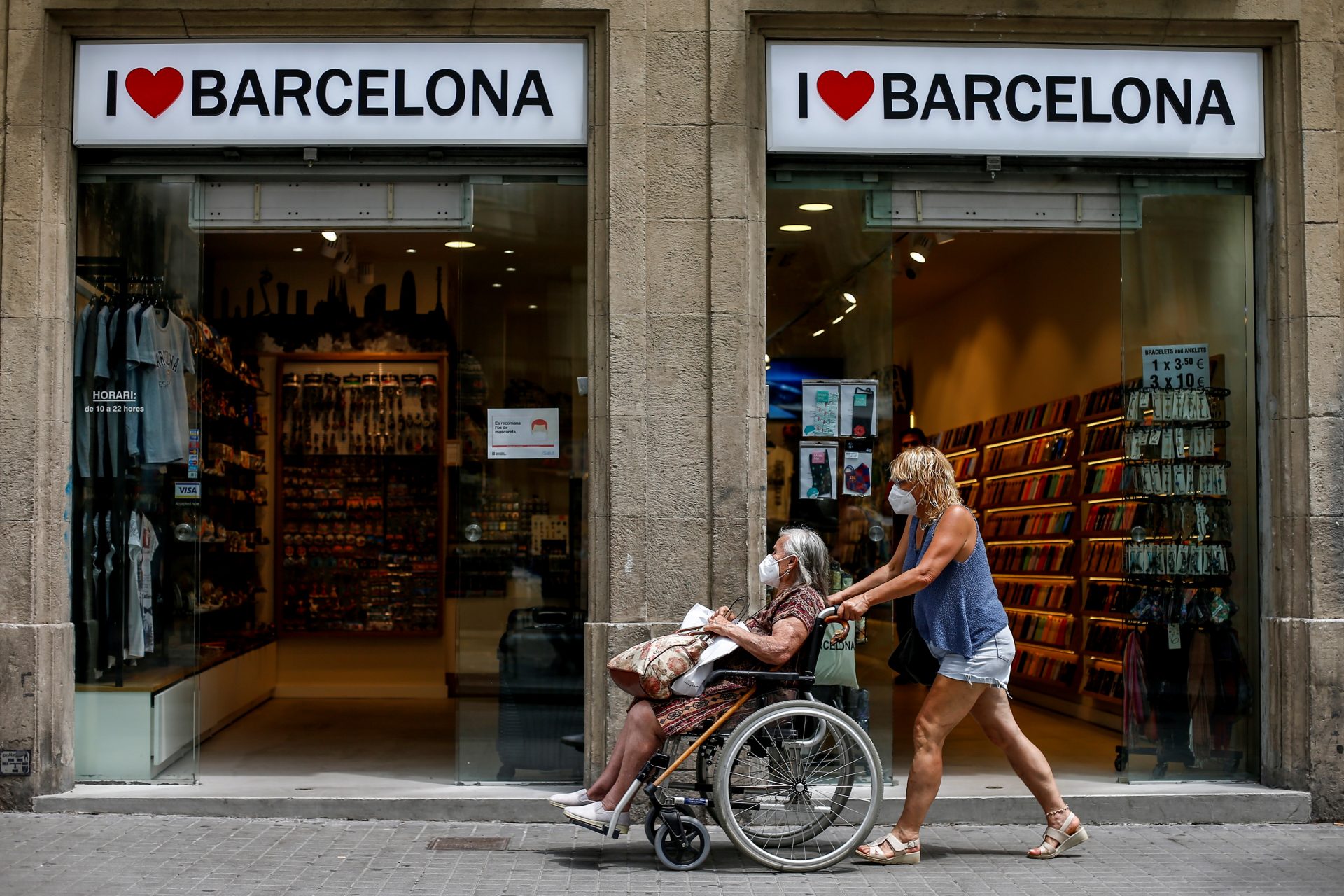Španija, koronavirus
epa08560548 A woman pushes a wheelchair in downtown in Barcelona, Spain, 22 July 2020. Catalonia has experienced a rise of new coronavirus cases in the last 24 hours.  EPA-EFE/Quique García