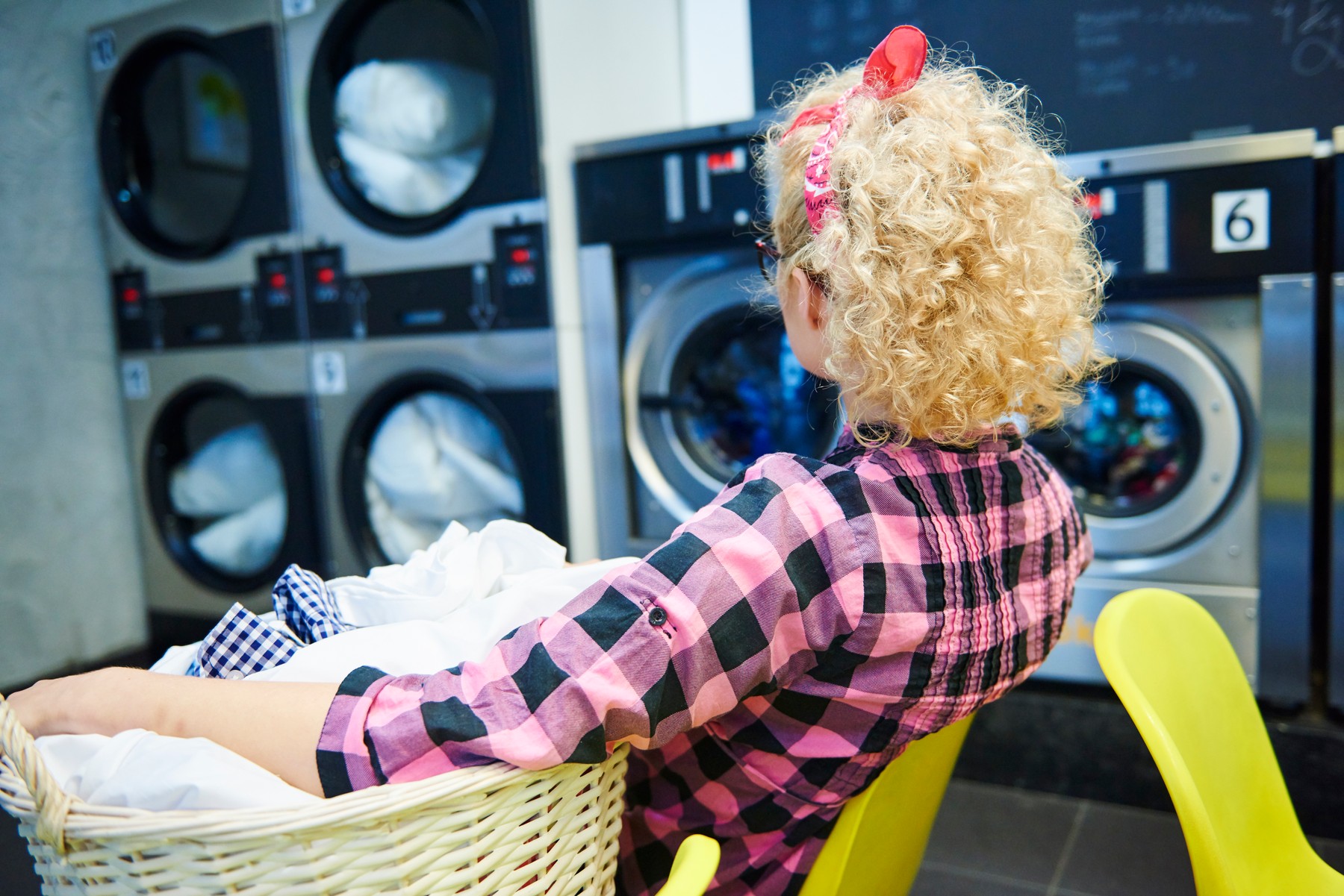 Woman watching washing machines in laundrette