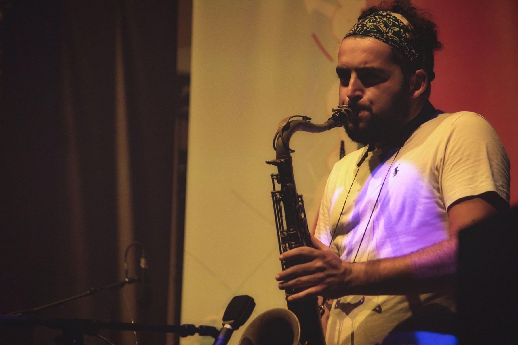 Valletta / Malta - September 1 2019: A young man with a beard playing the saxophone on stage at a music festival
