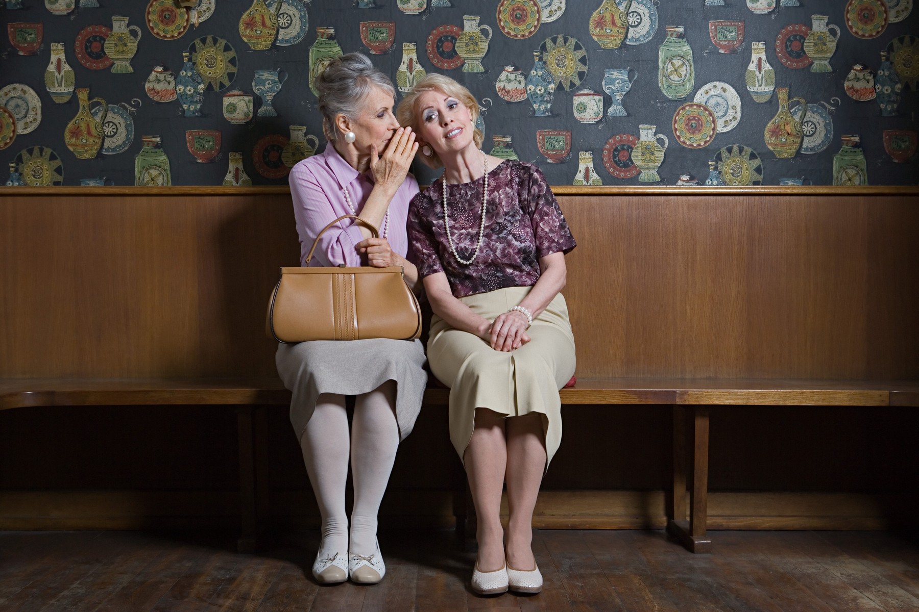Senior woman whispering to friend