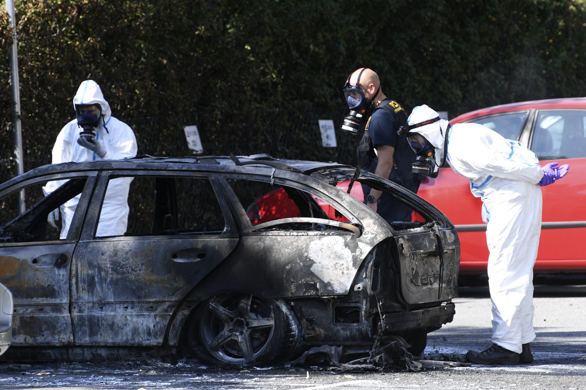 epa07795236 Police and criminal technical investigators examine a burnt out car near the crime scene where a woman was shot dead in Ribersborg, Malmo, 26 August 2019.  EPA-EFE/Johan Nilsson  SWEDEN OUT