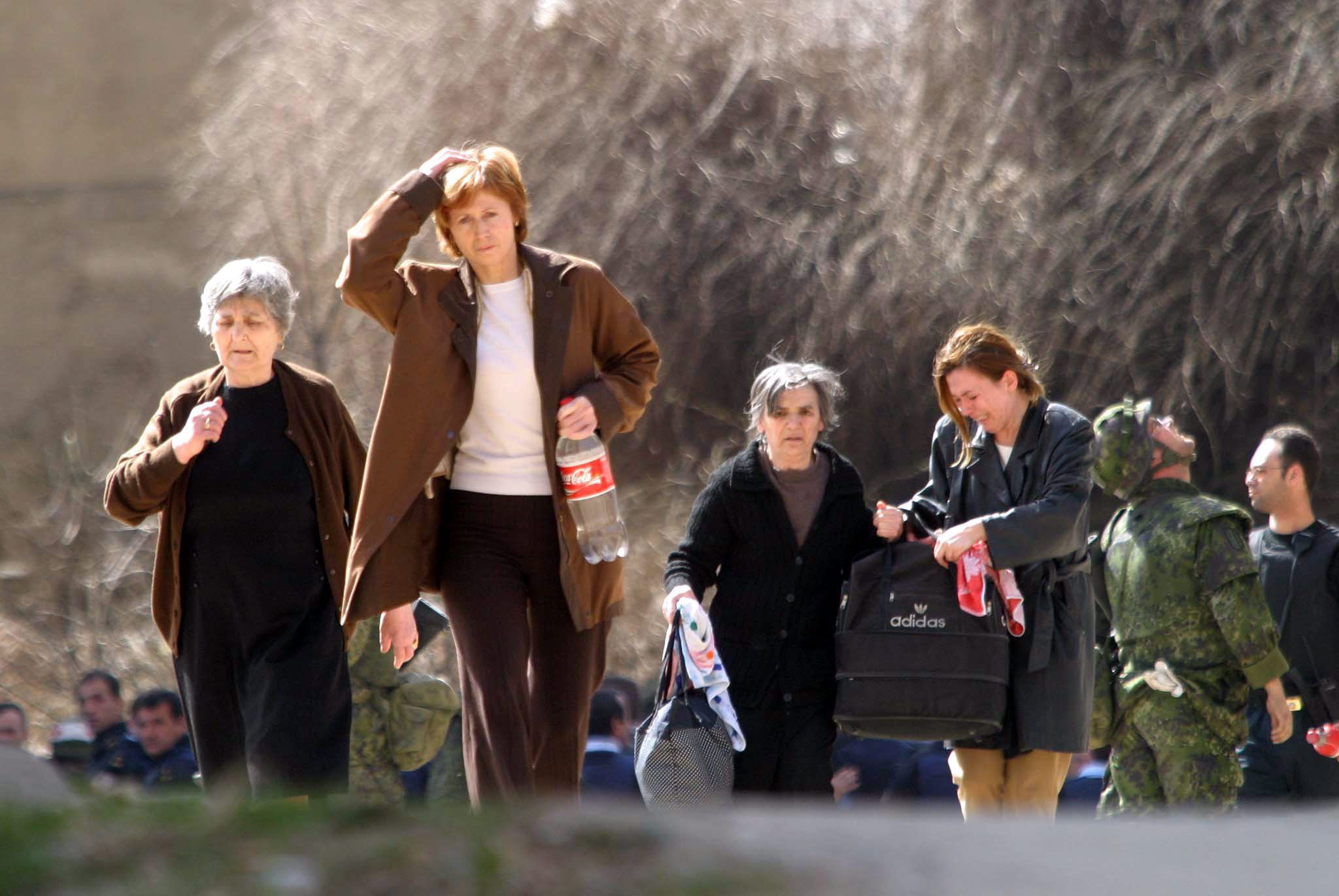 Kosovo pogrom epa00156433 Two Serb families are being evacuated from their homes in a mostly ethnic Albanian-populated apartment building in the northern Kosovo city of Kosovska Mitrovica, on Friday 19 of March 2004.  EPA/SASA STANKOVIC