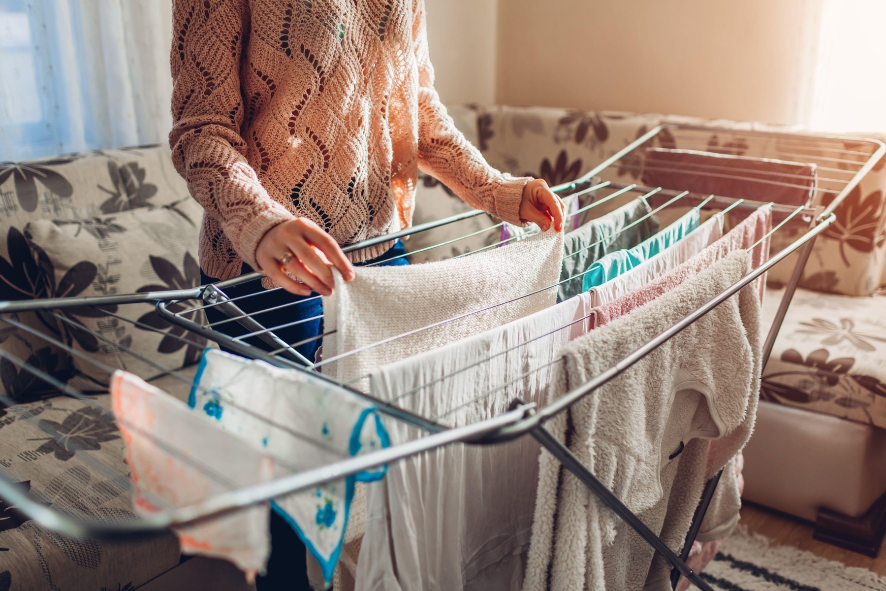 Woman hanging clean wet clothes on dryer after washing at home in living room. Housekeeping and household chores,Image: 493023006, License: Royalty-free, Restrictions: , Model Release: no, Credit line: Mariia Boiko / Alamy / Alamy / Profimedia