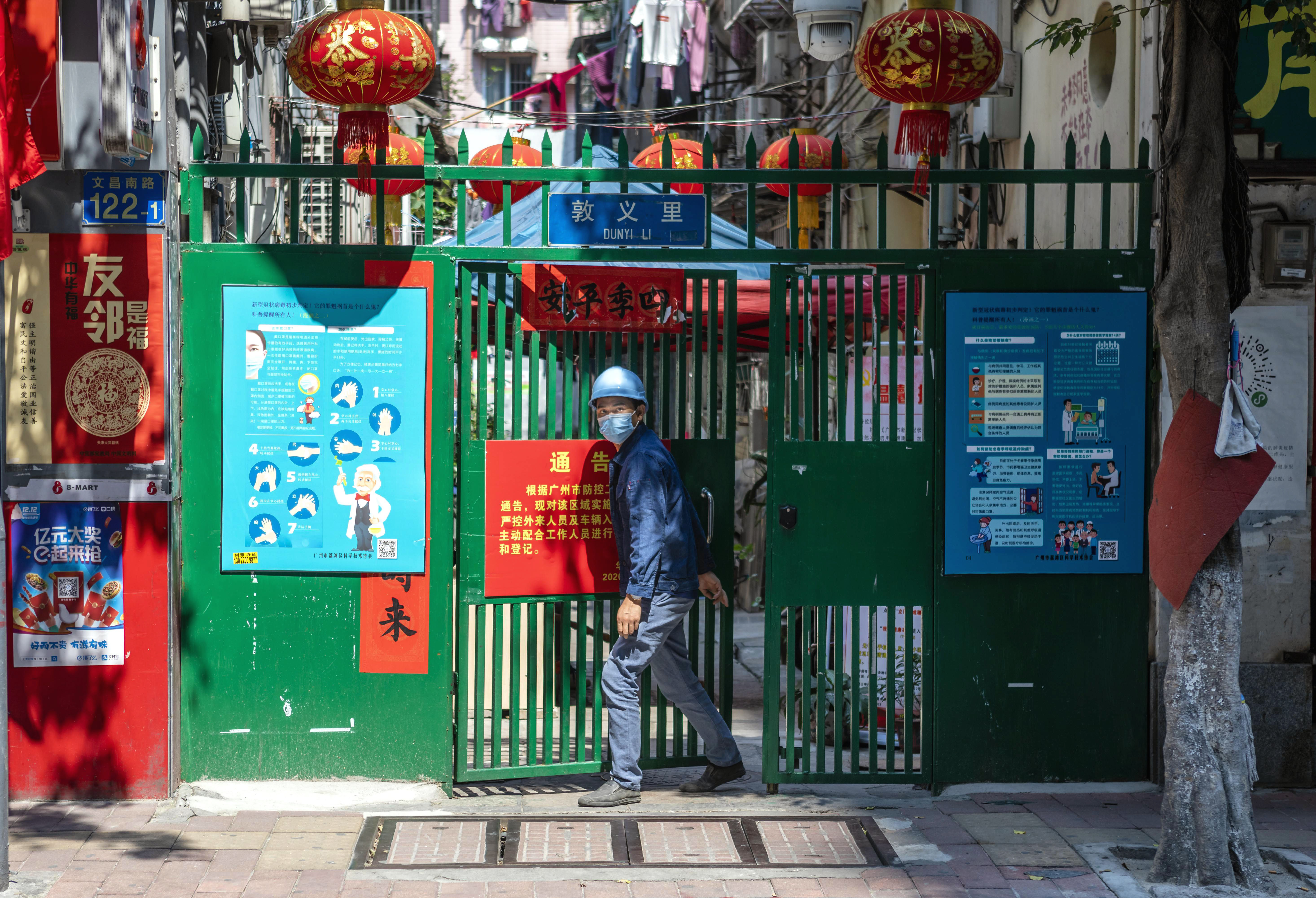 epa08394600 A man exits a community in Guangzhou, Guangdong province, China, 28 April 2020 (issued 01 May 2020).  EPA-EFE/ALEX PLAVEVSKI