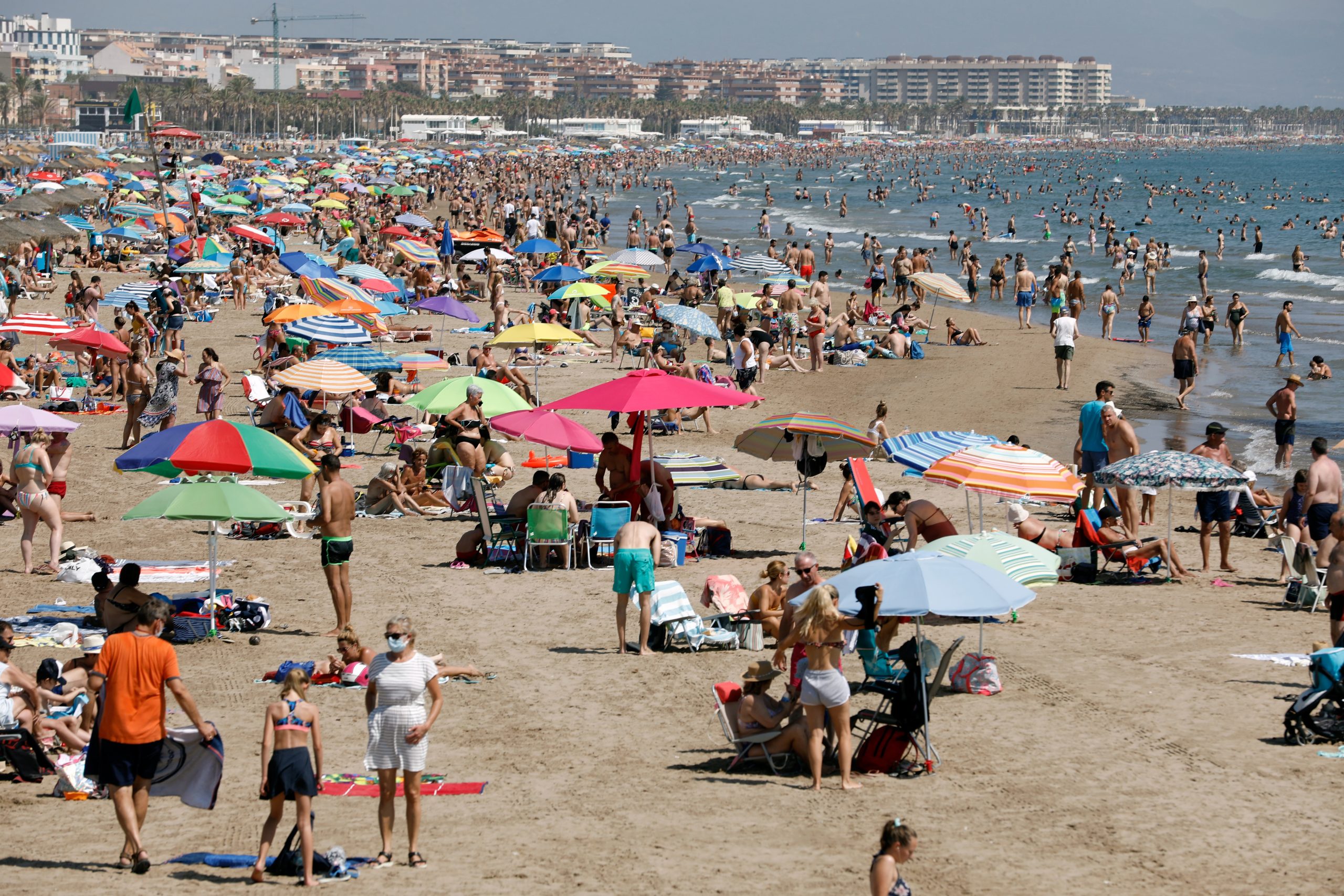 epa08554545 People sit on Malvarrosa beach in Valencia, Spain, 19 July 2020. New restrictions have been imposed in Valencia and surrounding towns after a spike in COVID-19 infection was reported.  EPA-EFE/Alejandro Garcia