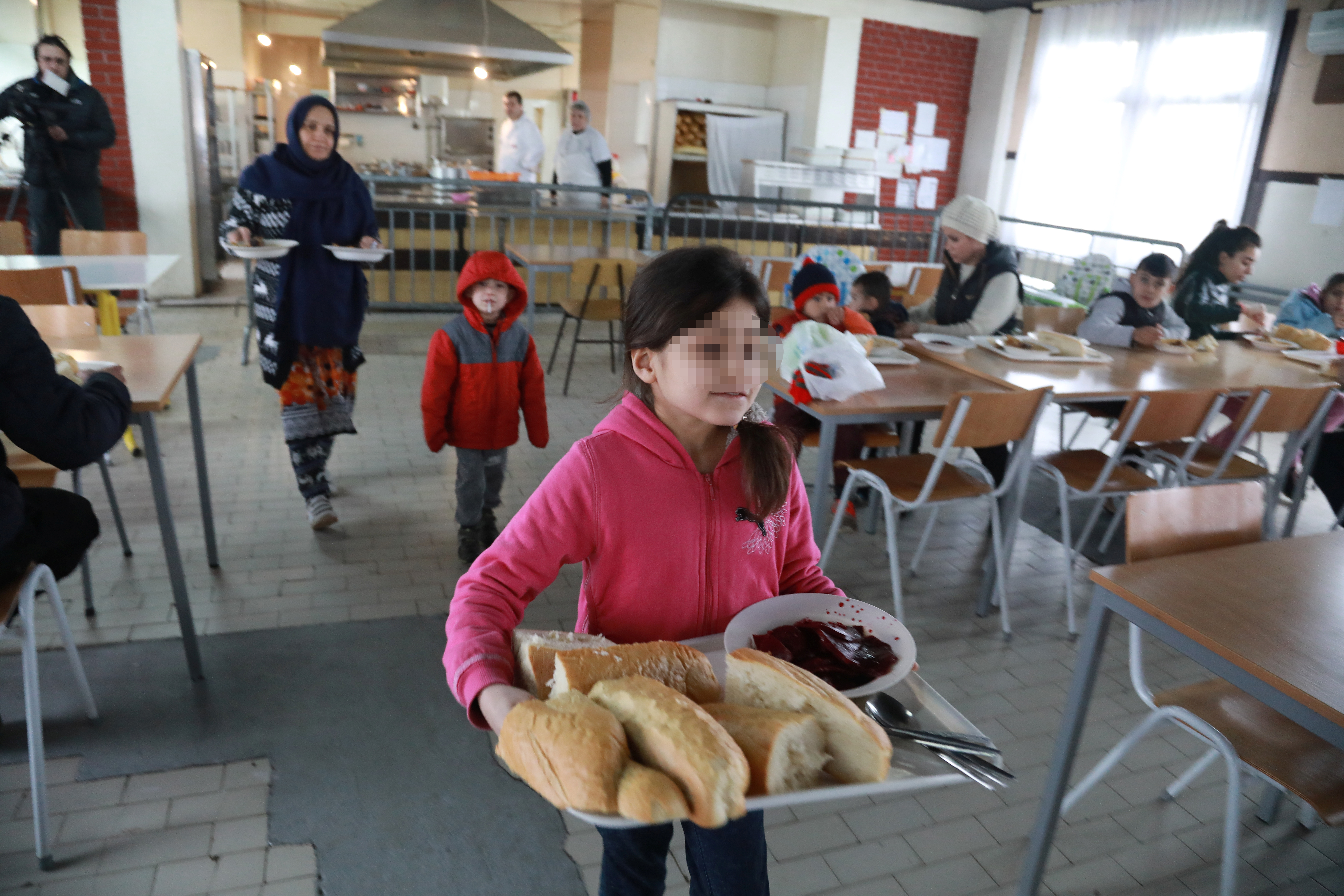 Migranti 
Sonya, 8, daughter of Afghan refugee Najibullah, carries food at the camp for refugees and migrants in the Belgrade suburb of Krnjaca, Serbia, January 16, 2018. Picture taken January 16, 2018 REUTERS/Djordje Kojadinovic - RC1838321FE0