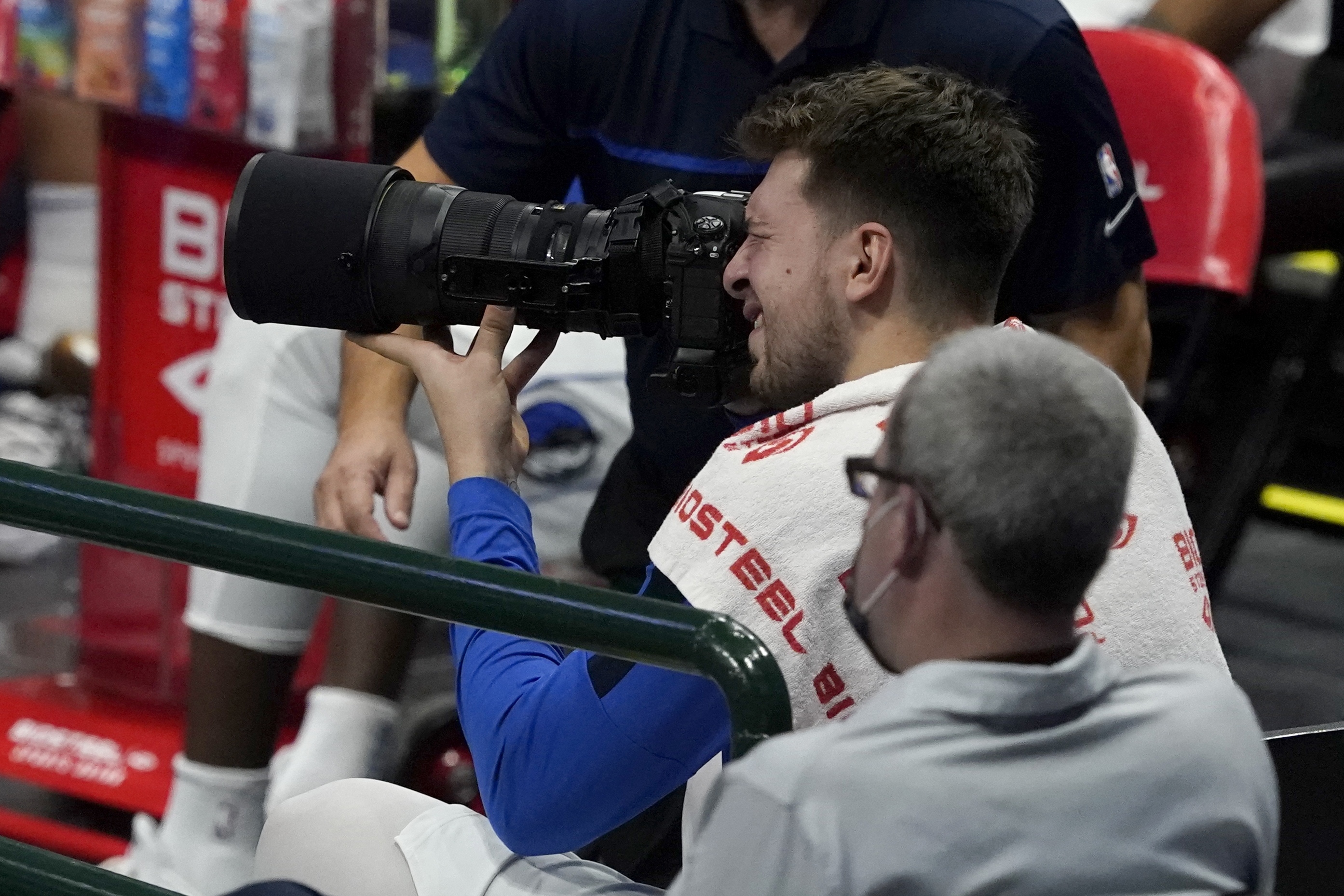 Dallas Mavericks guard Luka Doncic uses a photographers camera to pictures during the second half of an NBA preseason basketball game against the Minnesota Timberwolves in Dallas, Thursday, Dec. 17, 2020. (AP Photo/Tony Gutierrez)