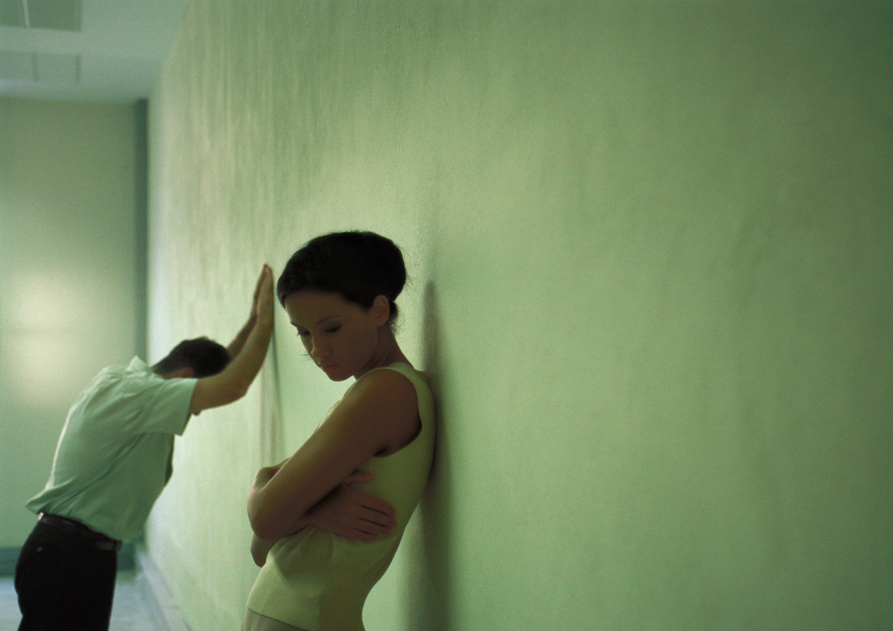 Woman with back against wall, arms folded, man in background leaning despondently against wall,Image: 70054342, License: Royalty-free, Restrictions: , Model Release: yes, Credit line: Frederic Cirou / PhotoAlto / Profimedia