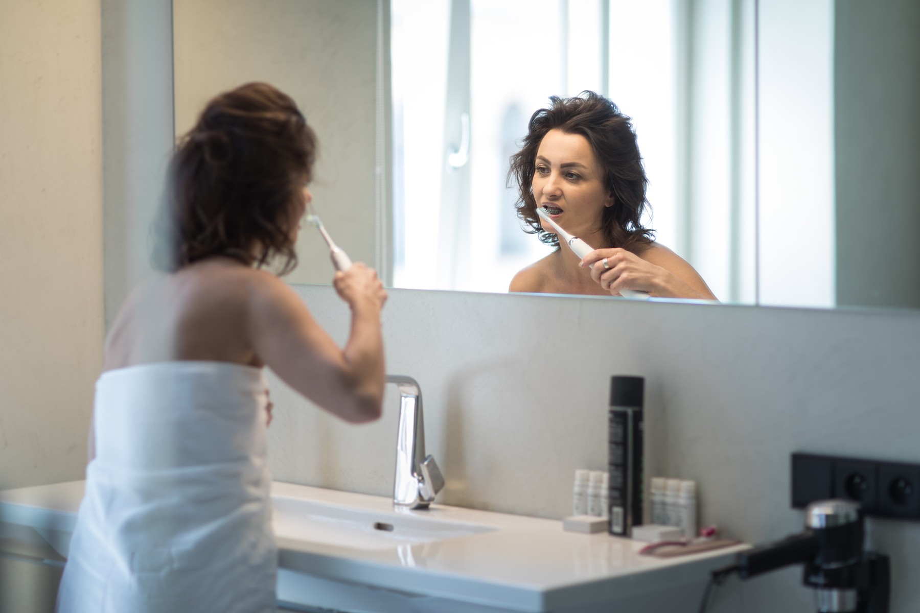Pretty,  middle aged woman brushing her teeth with braces in a modern design bathroom,Image: 492653276, License: Royalty-free, Restrictions: , Model Release: yes, Credit line: Viktor Cap / Panthermedia / Profimedia