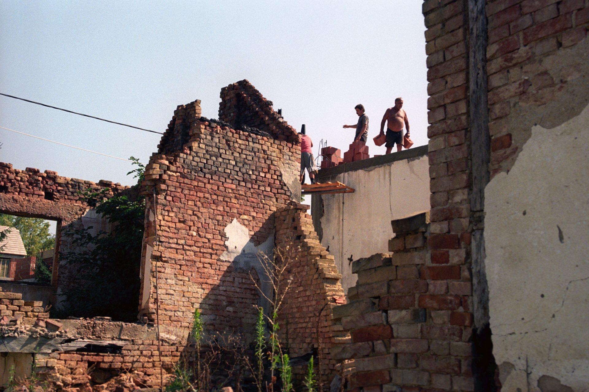 Local people work at the ruins of their house in Nova Gradiska, Croatia, 12 August 1995. EPA/ATTILA KISBENEDEK