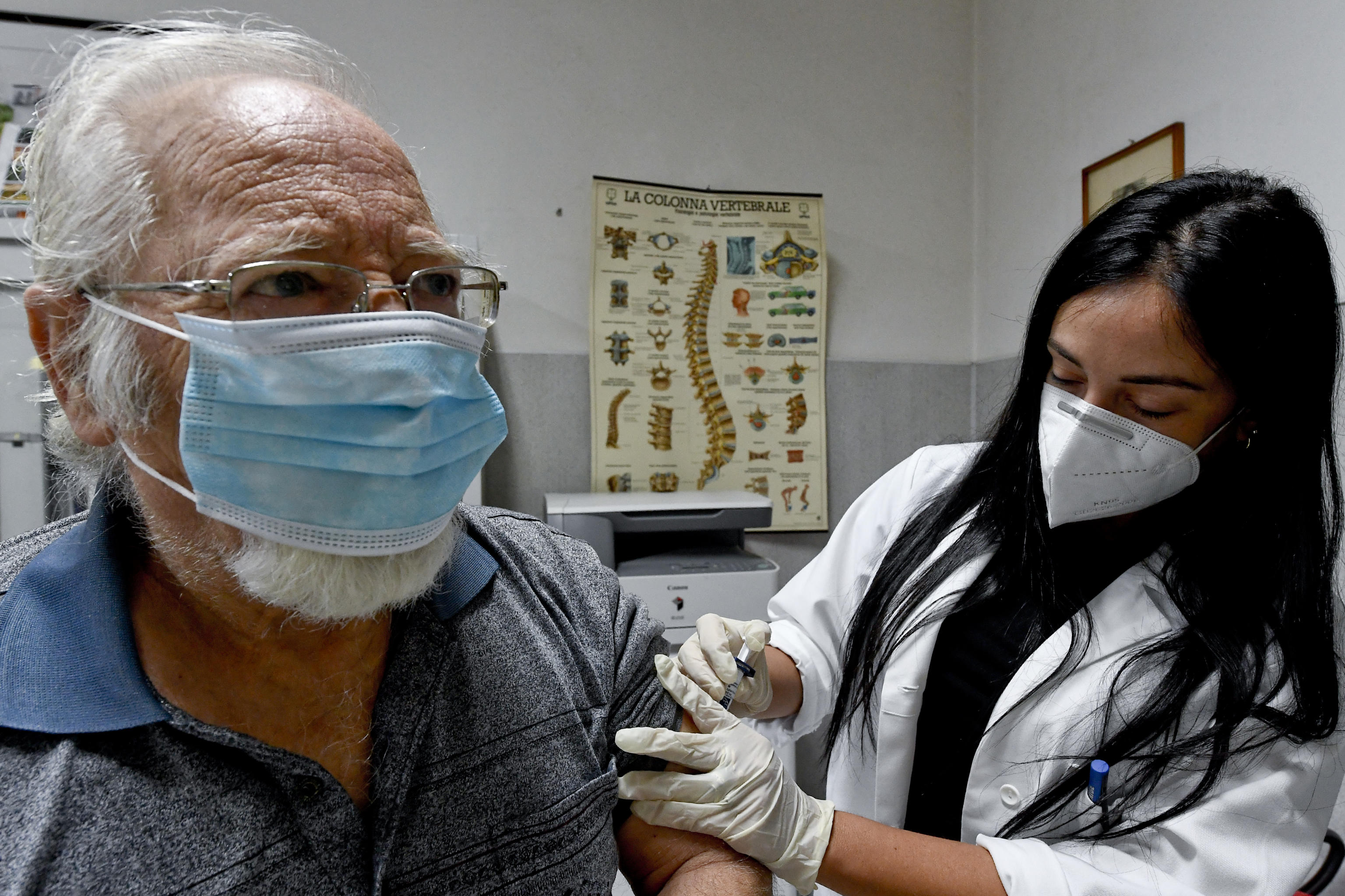 epa08726321 A doctor administers a dose of flu vaccine to an elderly patient in a medical office in Torre del Greco, near Naples, Italy, 07 October 2020.  EPA-EFE/CIRO FUSCO