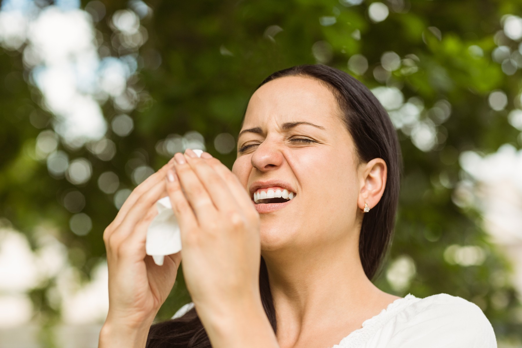 Sick brunette holding tissue sneezing in the park,Image: 216113472, License: Royalty-free, Restrictions: , Model Release: yes, Credit line: - / Wavebreak / Profimedia