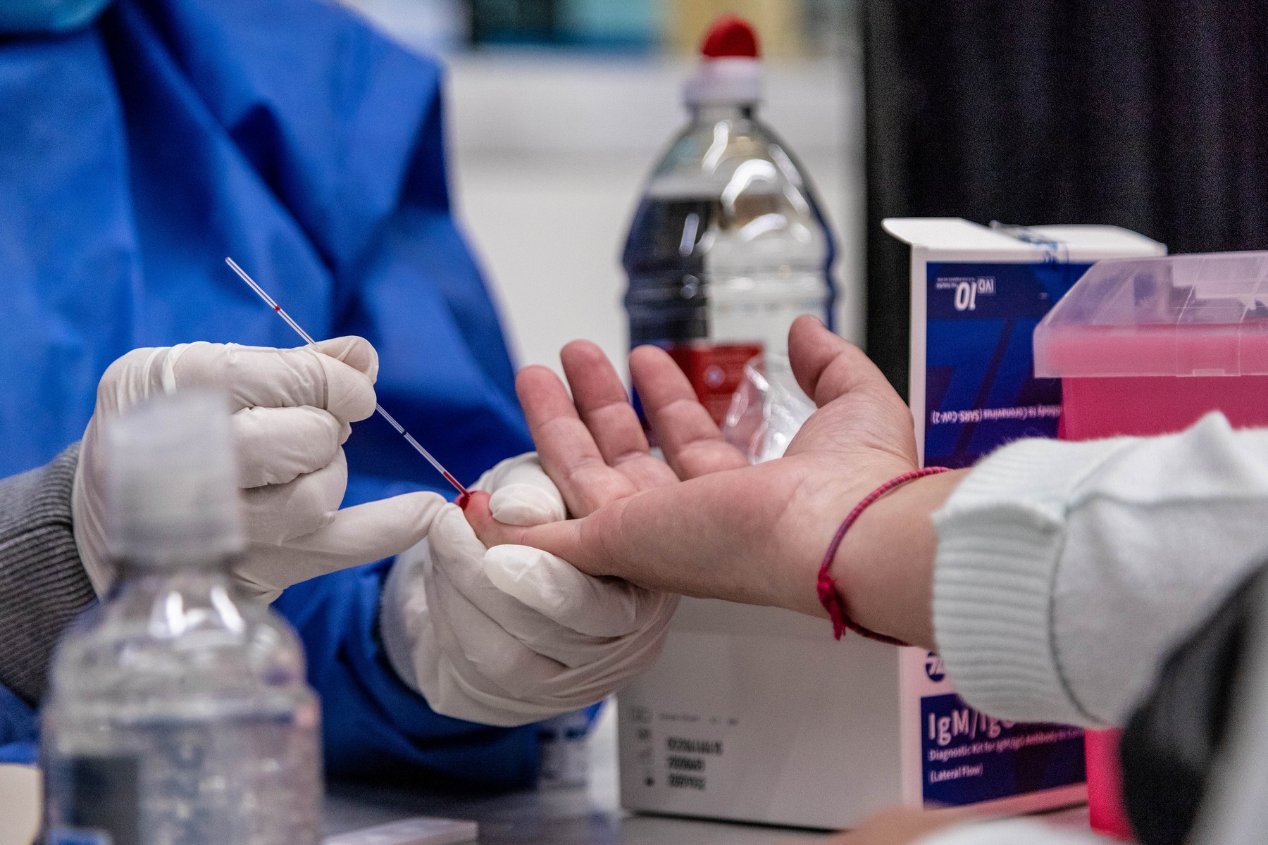 A woman pricks the finger to draw blood from a test subject during a massive tests in Constitution Station to detect people who would have had the Coronavirus more than 20 days ago. Buenos Aires, Argentina - April 24, 2020.