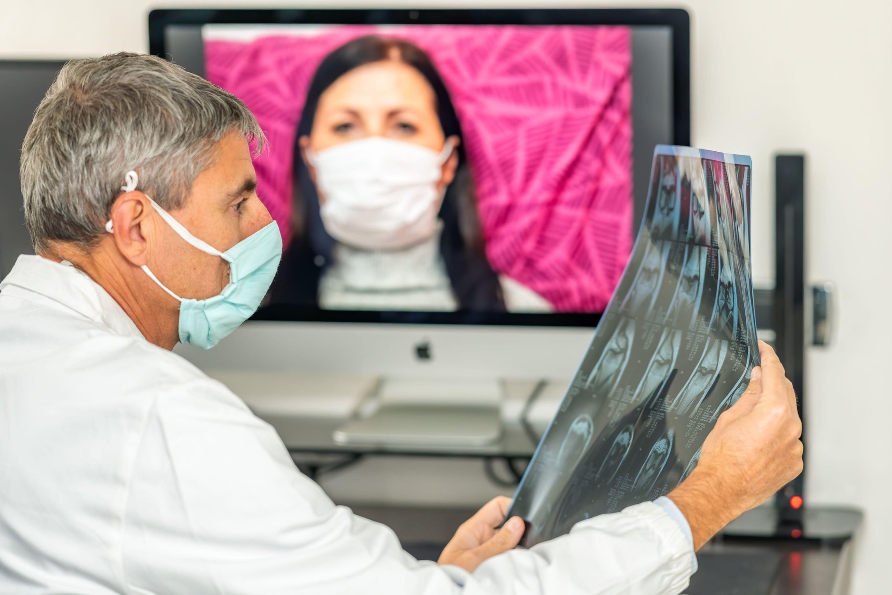 Back view of doctor making video call with his patient at home. Close up of patient in video conferencing with general practitioner with computer. Sic
