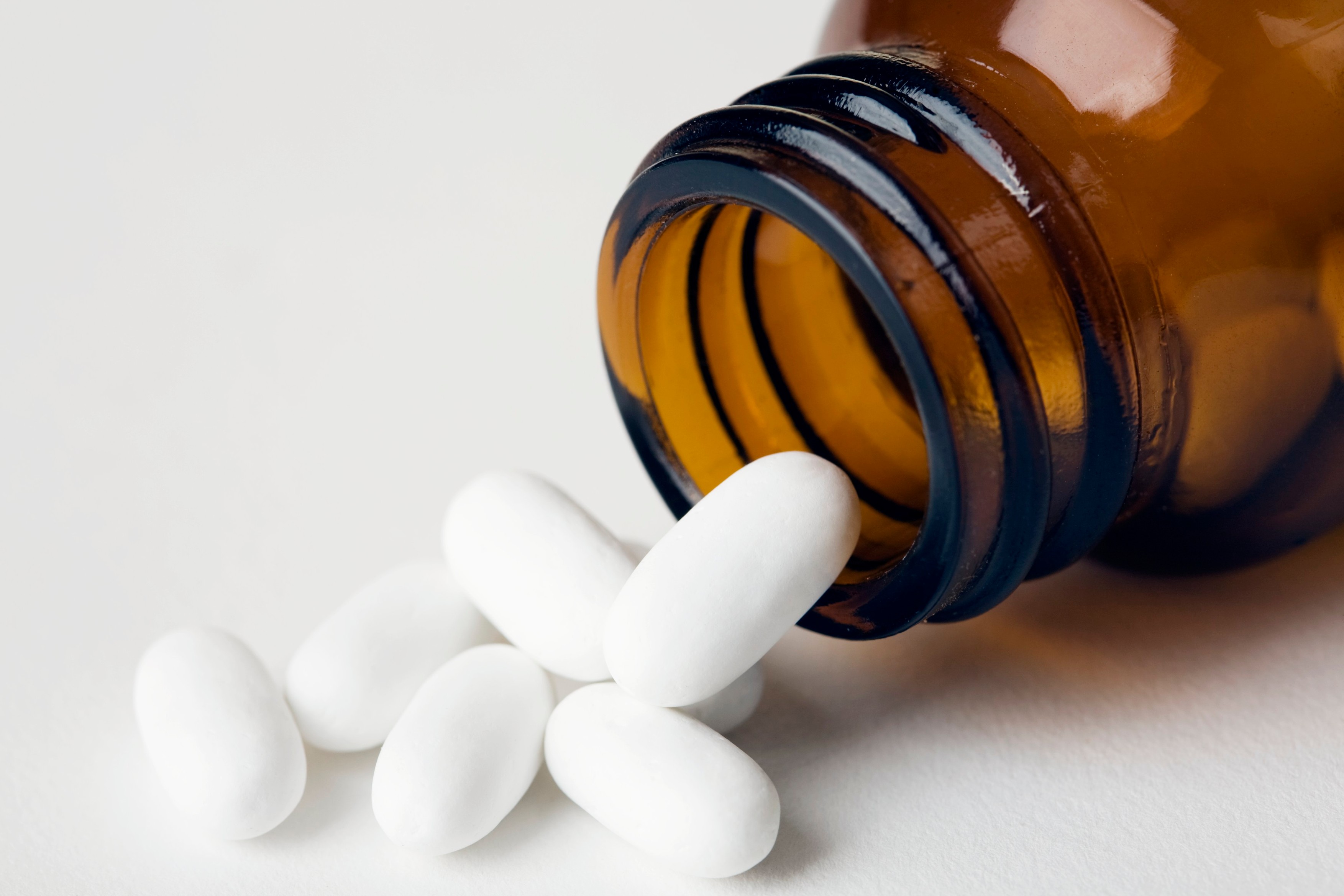 Ibuprofen pills spilling from a pot. Ibuprofen is a painkilling anti-inflammatory drug., Image: 102387439, License: Rights-managed, Restrictions: , Model Release: no, Credit line: Science Photo Library / Sciencephoto / Profimedia