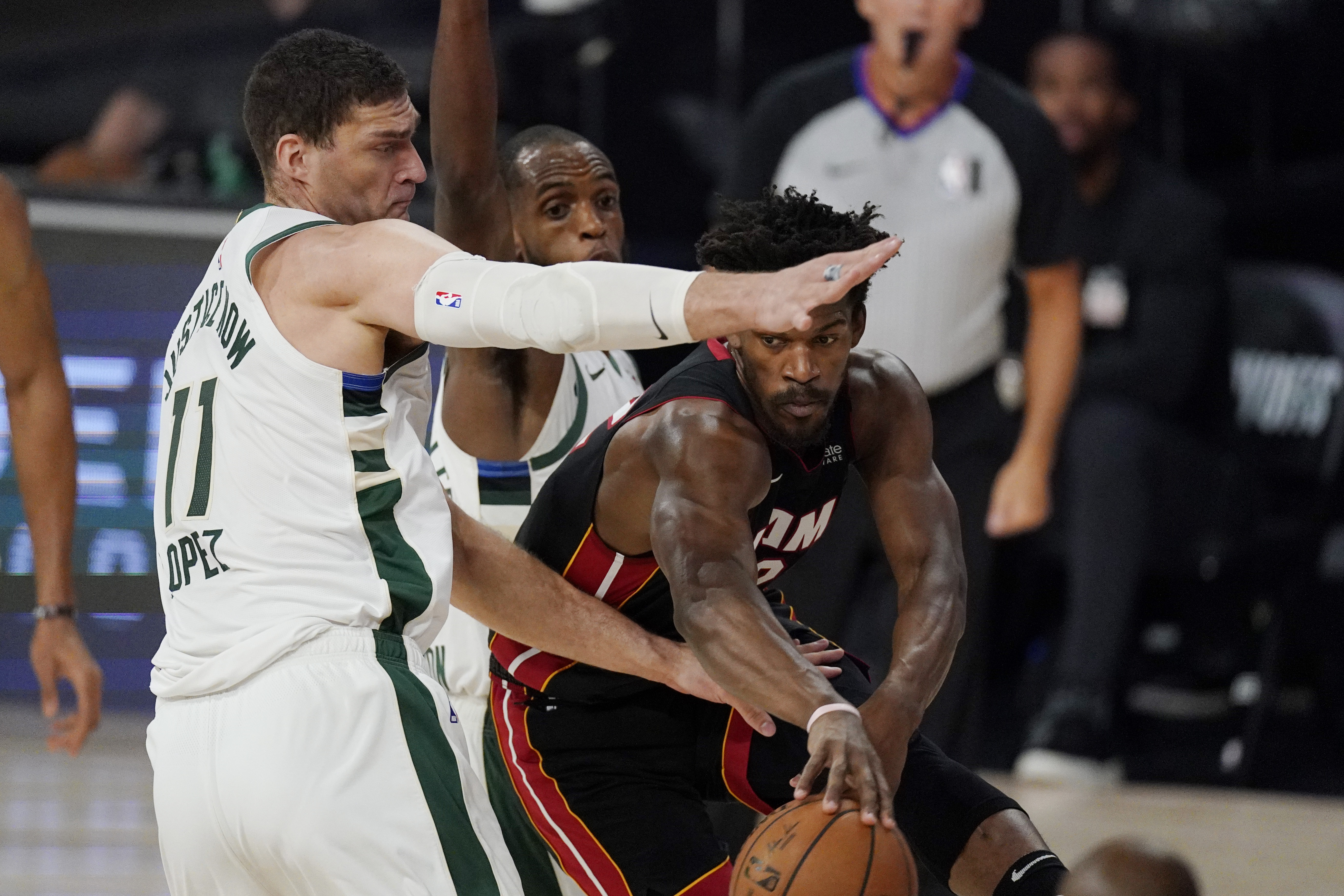 Miami Heat's Jimmy Butler, right, drives around Milwaukee Bucks' Brook Lopez (11) in the first half of an NBA conference semifinal playoff basketball game Friday, Sept. 4, 2020, in Lake Buena Vista, Fla. (AP Photo/Mark J. Terrill)