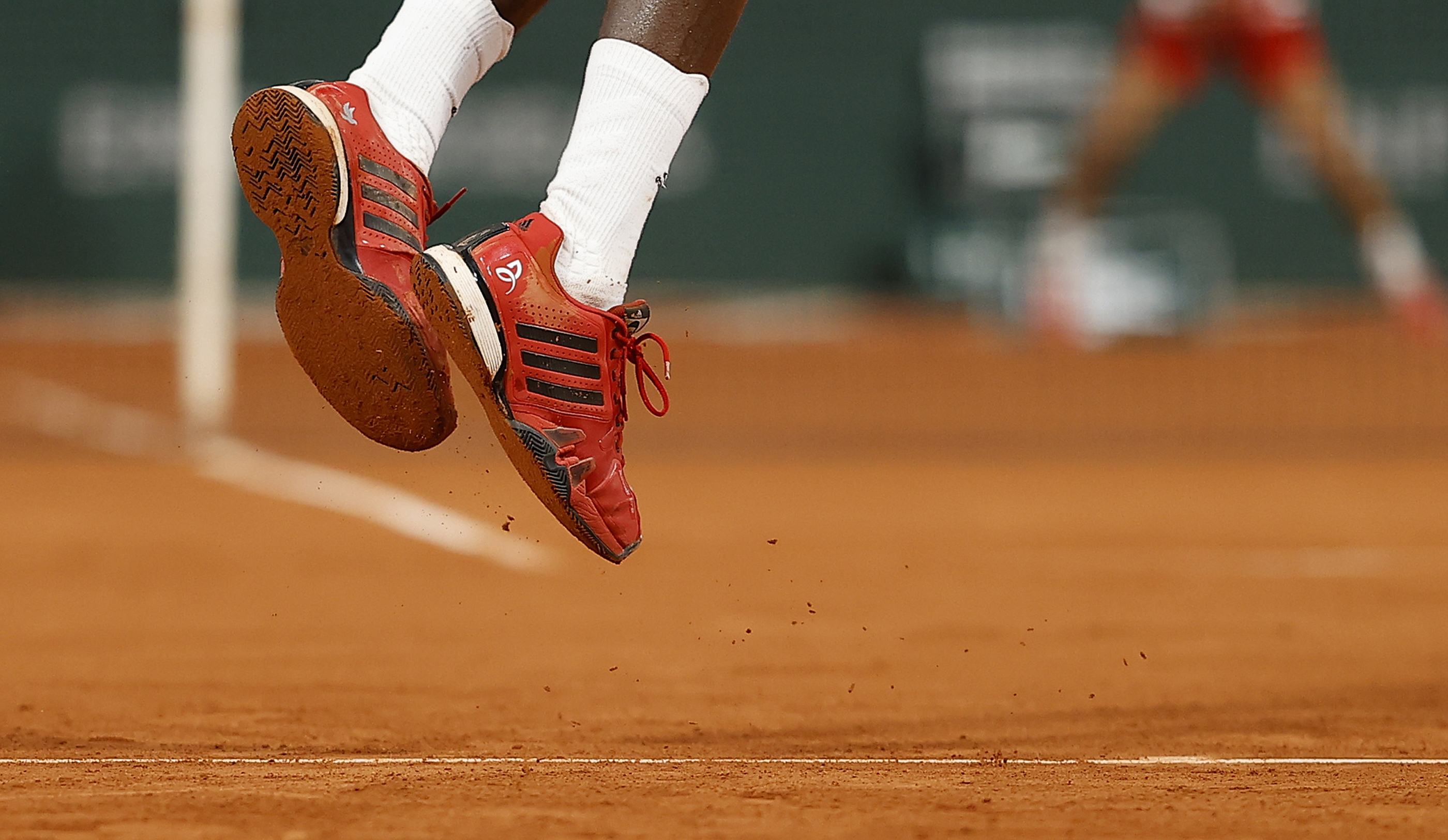 epa08706137 Mikael Ymer of Sweden wears Djokovic branded shoes during his first round match against Novak Djokovic of Serbia at the French Open tennis tournament at Roland Garros in Paris, France, 29 September 2020.  EPA-EFE/IAN LANGSDON