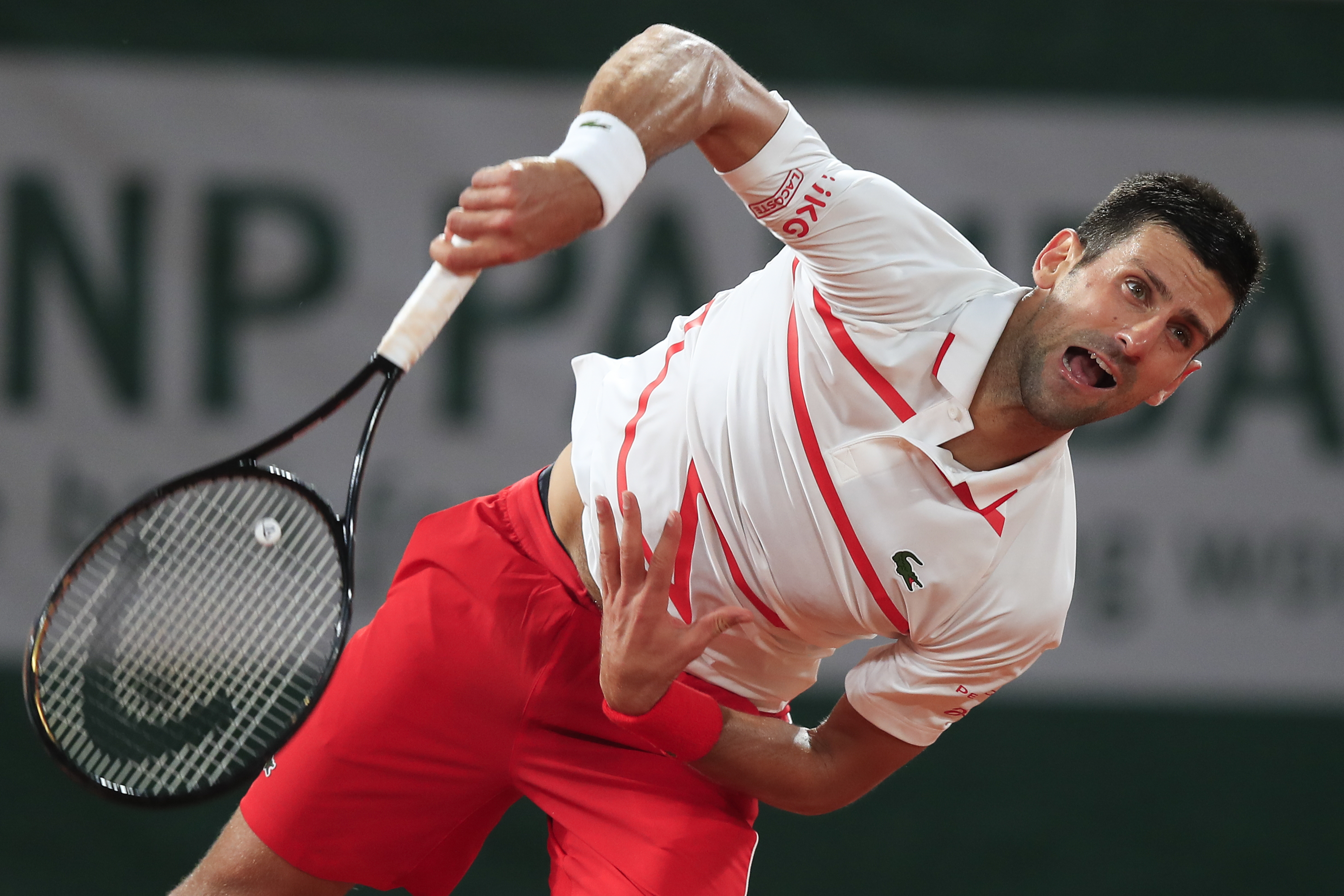Serbia's Novak Djokovic serves against Sweden's Mikael Ymer in the first round match of the French Open tennis tournament at the Roland Garros stadium in Paris, France, Tuesday, Sept. 29, 2020. (AP Photo/Michel Euler)