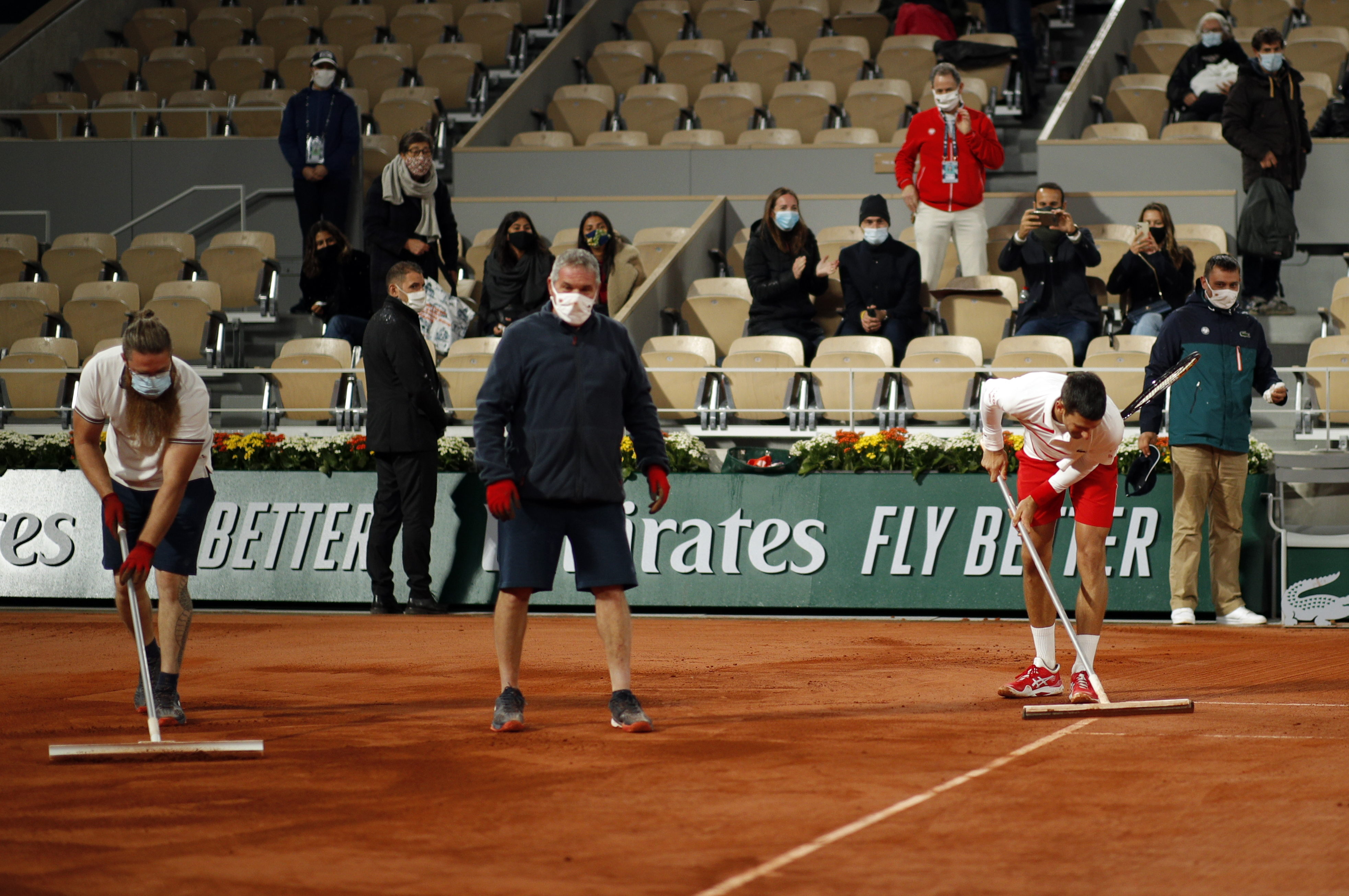 epa08718370 Staff prepares the court as Novak Djokovic of Serbia plays Daniel Elahi Galan of Colombia during their men?s third round match during the French Open tennis tournament at Roland ?Garros in Paris, France, 03 October 2020.  EPA-EFE/YOAN VALAT