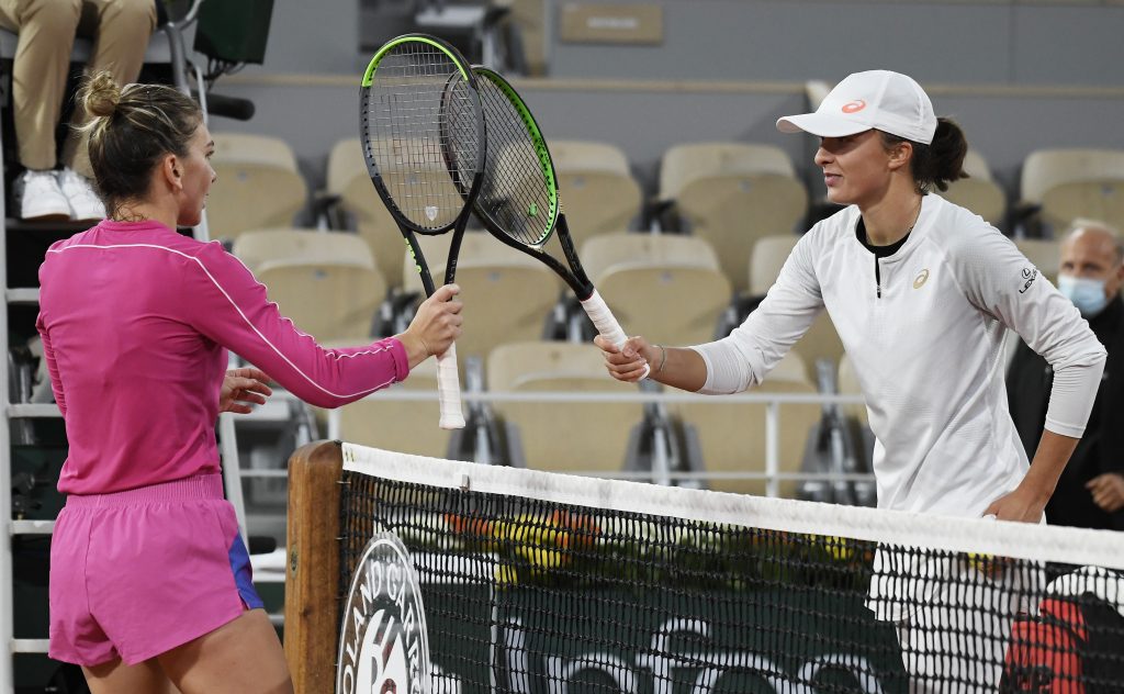 epa08719224 Iga Swiatek (R) of Poland is conratulated by  Simona Halep of Romania at the net after winning their 4th round match at the French Open tennis tournament at Roland Garros in Paris, France, 04 October 2020.  EPA-EFE/JULIEN DE ROSA