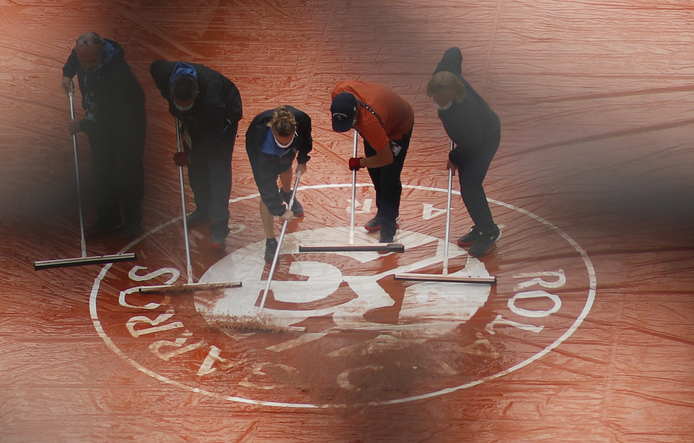 epa08705802 Ground staff remove water from the cover on one of the courts during a rain break on the third day of the French Open tennis tournament at Roland Garros in Paris, France, 29 September 2020  EPA-EFE/YOAN VALAT
