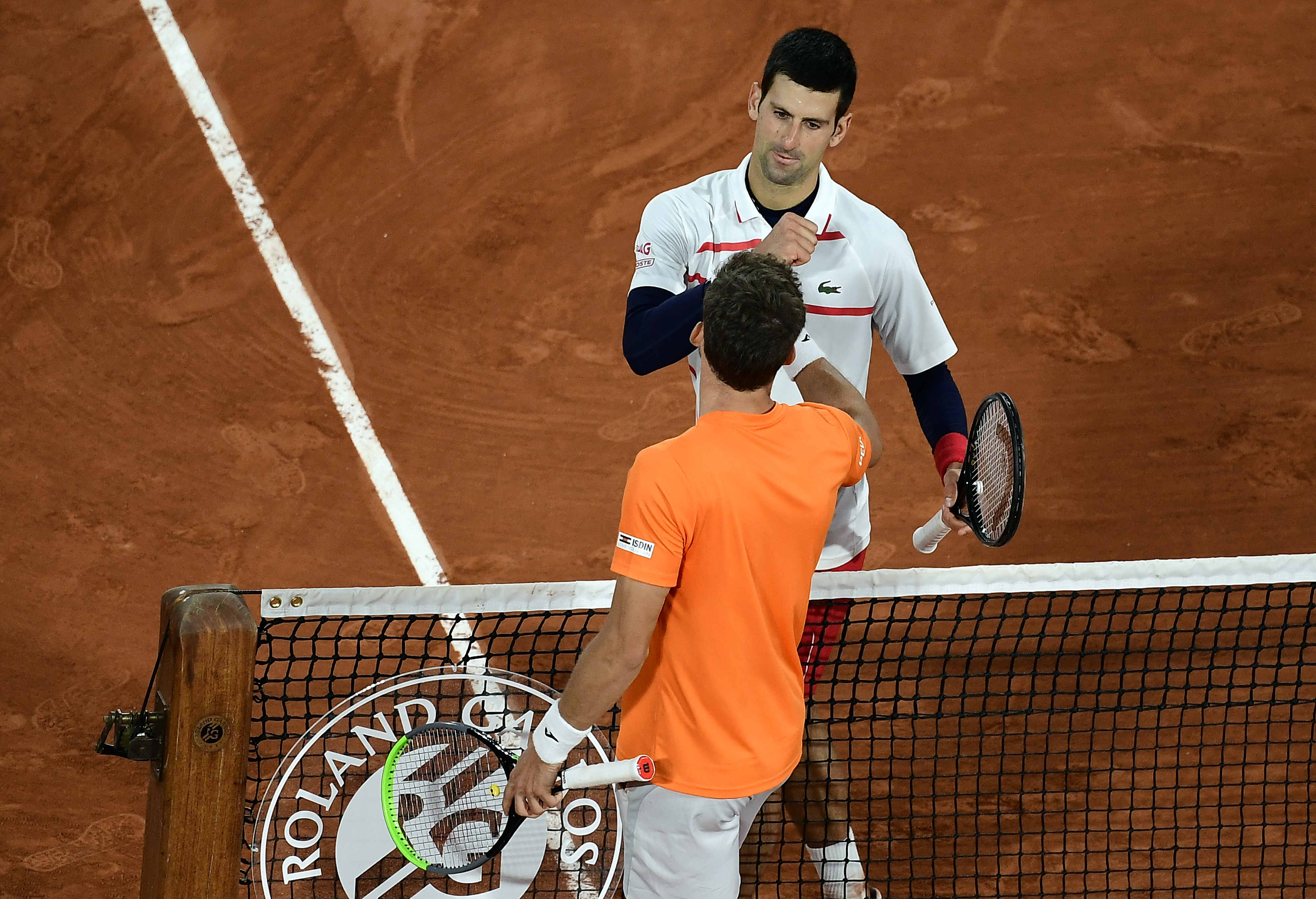 epa08727757 Novak Djokovic of Serbia (R) reacts with Pablo Carreno Busta of Spain after winning their men?s quarter final match during the French Open tennis tournament at Roland ?Garros in Paris, France, 07 October 2020.  EPA-EFE/JULIEN DE ROSA