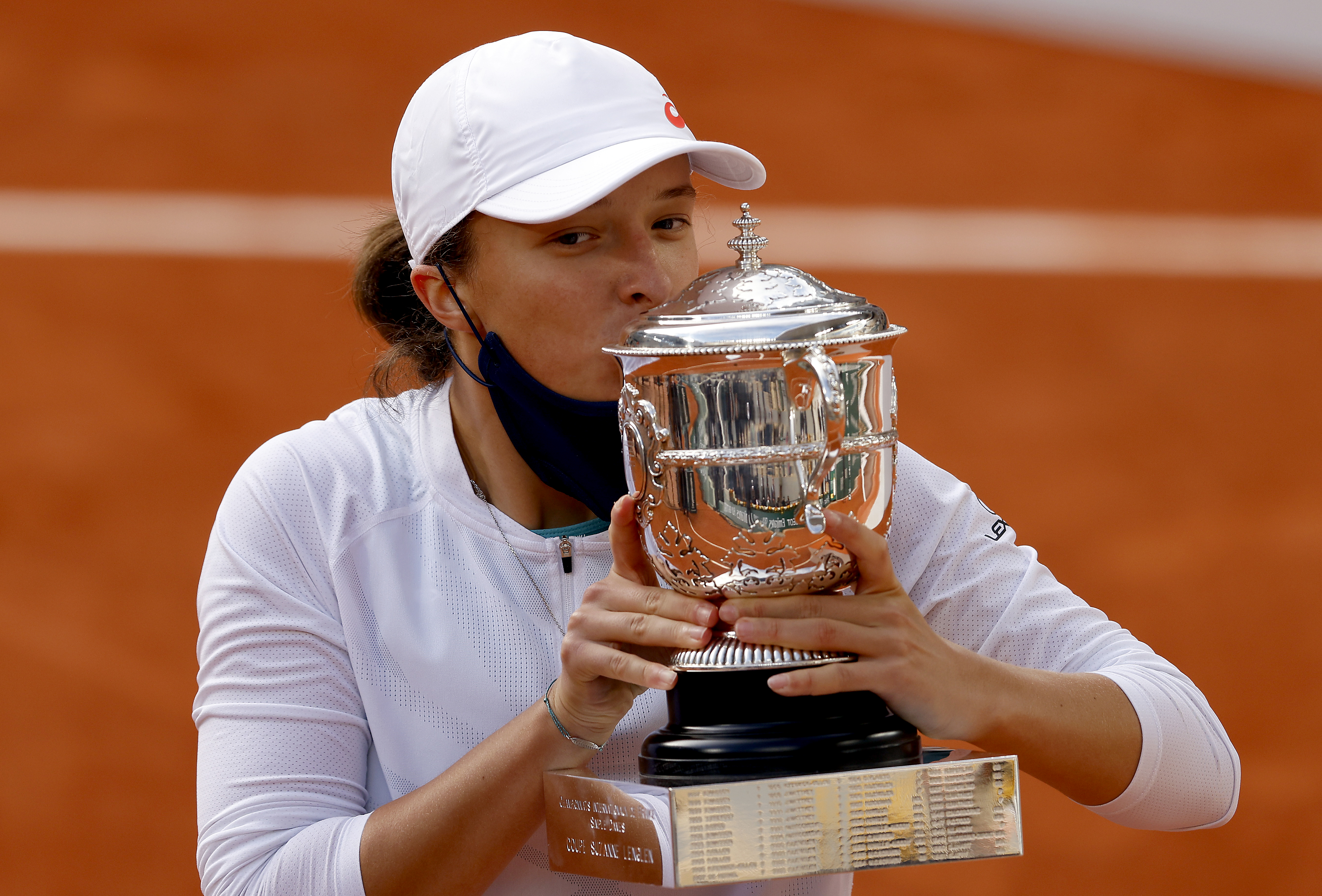 epa08734336 Iga Swiatek of Poland celebrates with the trophy after winning against Sofia Kenin of the USA in their women?s final match during the French Open tennis tournament at Roland ?Garros in Paris, France, 10 October 2020.  EPA-EFE/YOAN VALAT