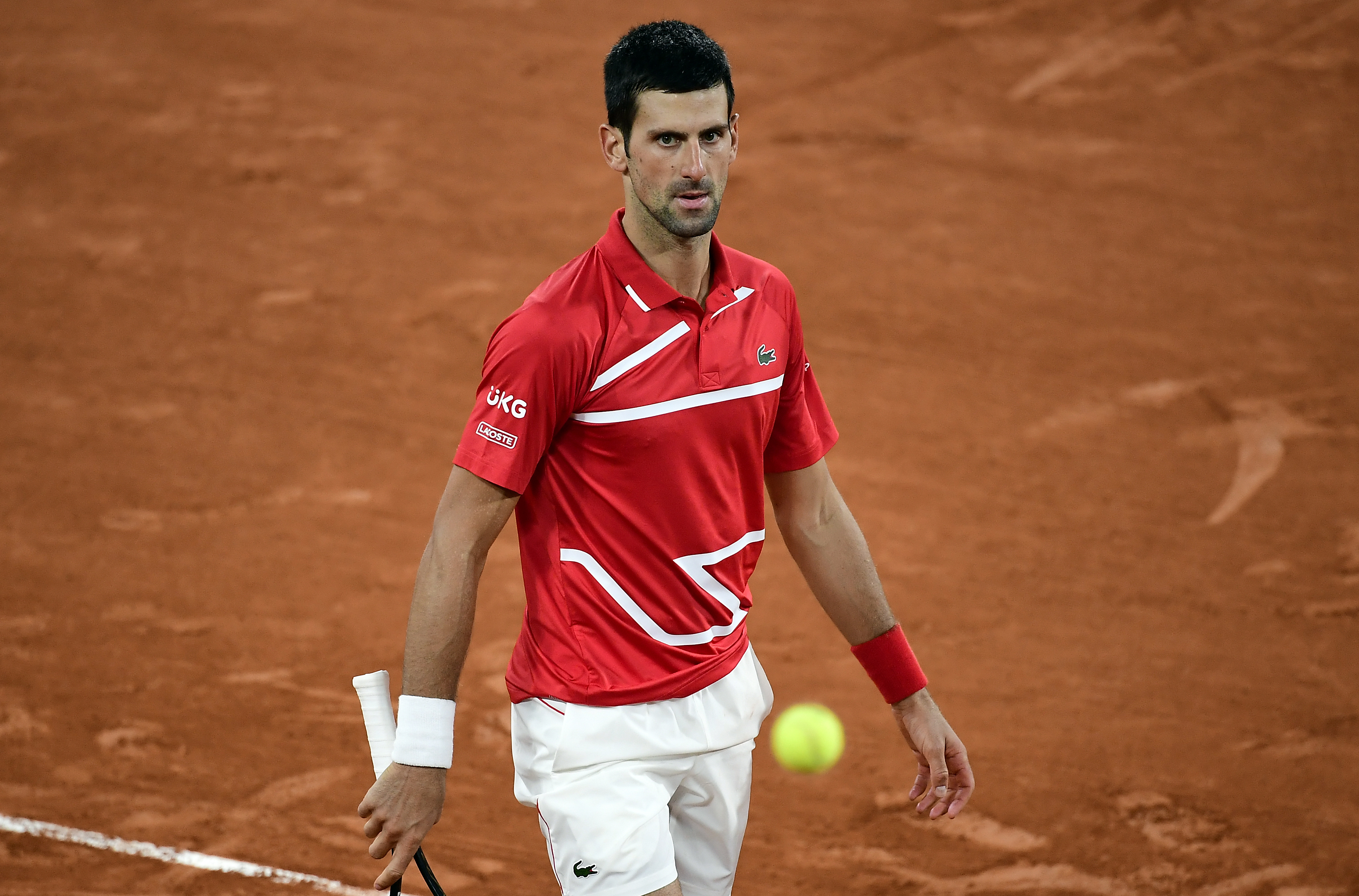 epa08733000 Novak Djokovic of Serbia reacts as he plays Stefanos Tsitsipas of Greece during their men?s semi final match during the French Open tennis tournament at Roland ?Garros in Paris, France, 09 October 2020.  EPA-EFE/JULIEN DE ROSA