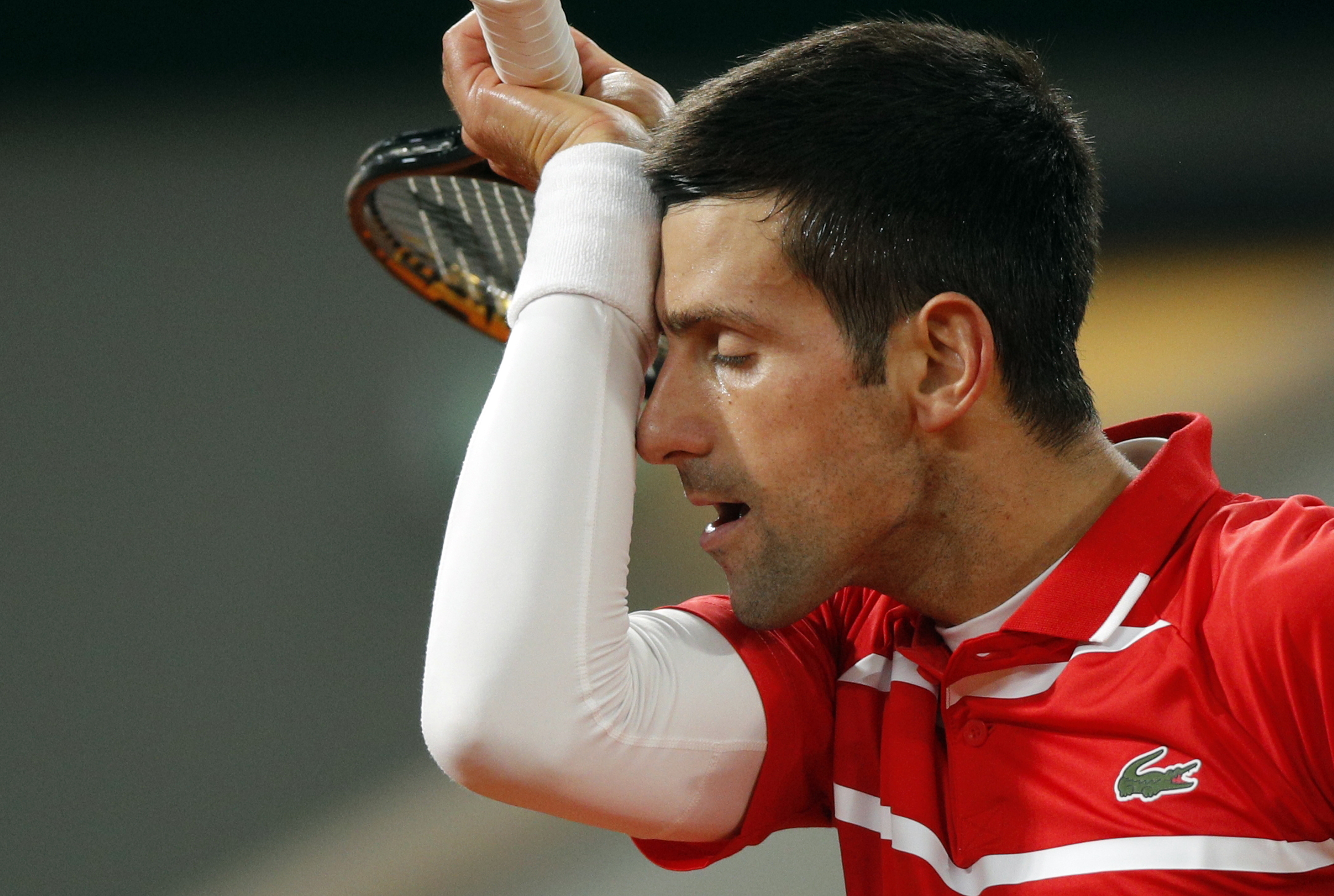 epaselect epa08735747 Novak Djokovic of Serbia reacts as he plays Rafael Nadal of Spain during their men?s final match during the French Open tennis tournament at Roland ?Garros in Paris, France, 11 October 2020.  EPA-EFE/YOAN VALAT
