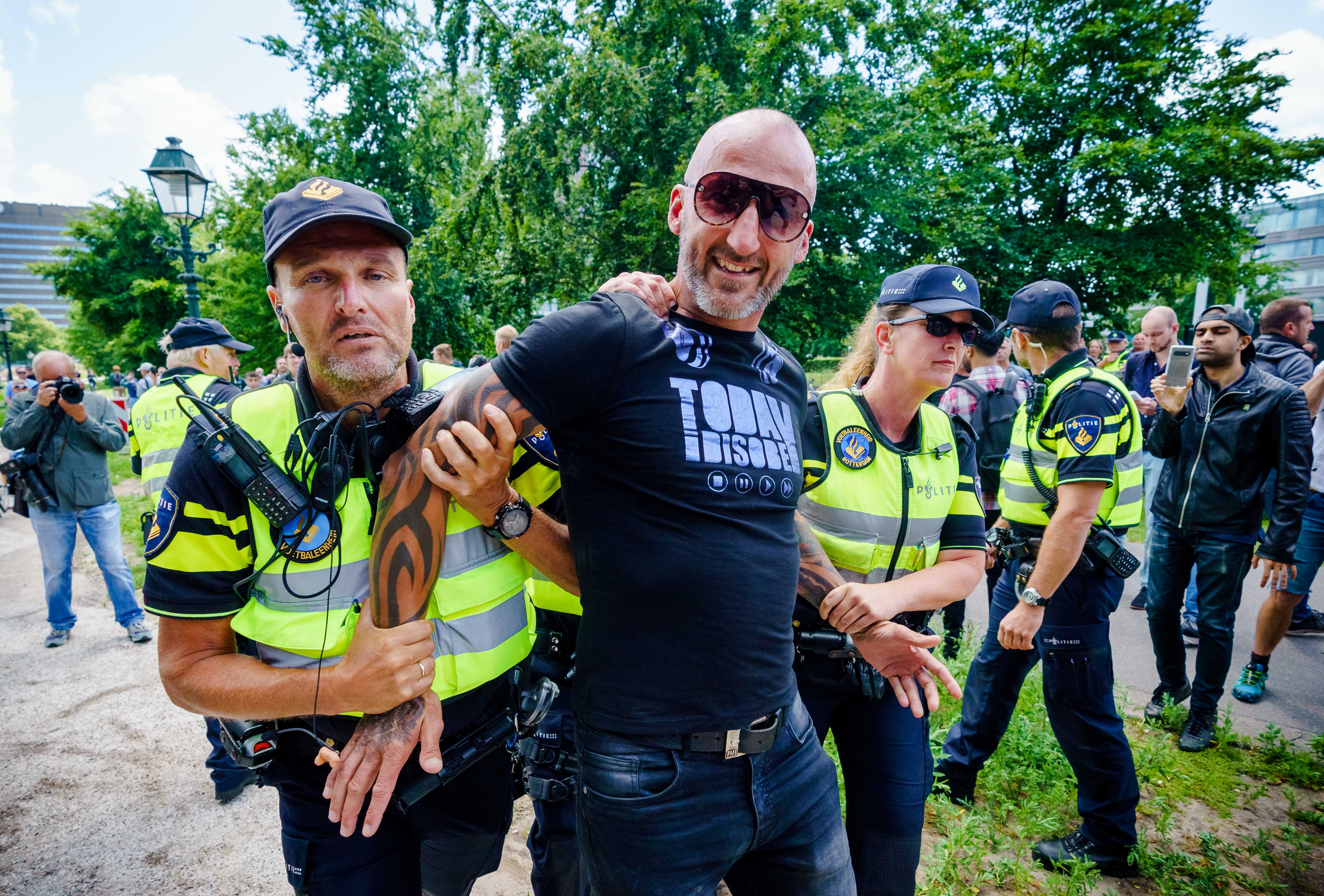 epa08514209 A participant is detained during the prohibited 'Virus Madness' demonstration, which is aimed at the government's corona measures, on the Malieveld in The Hague, The Netherlands, 28 June 2020.  EPA-EFE/MARCO DE SWART