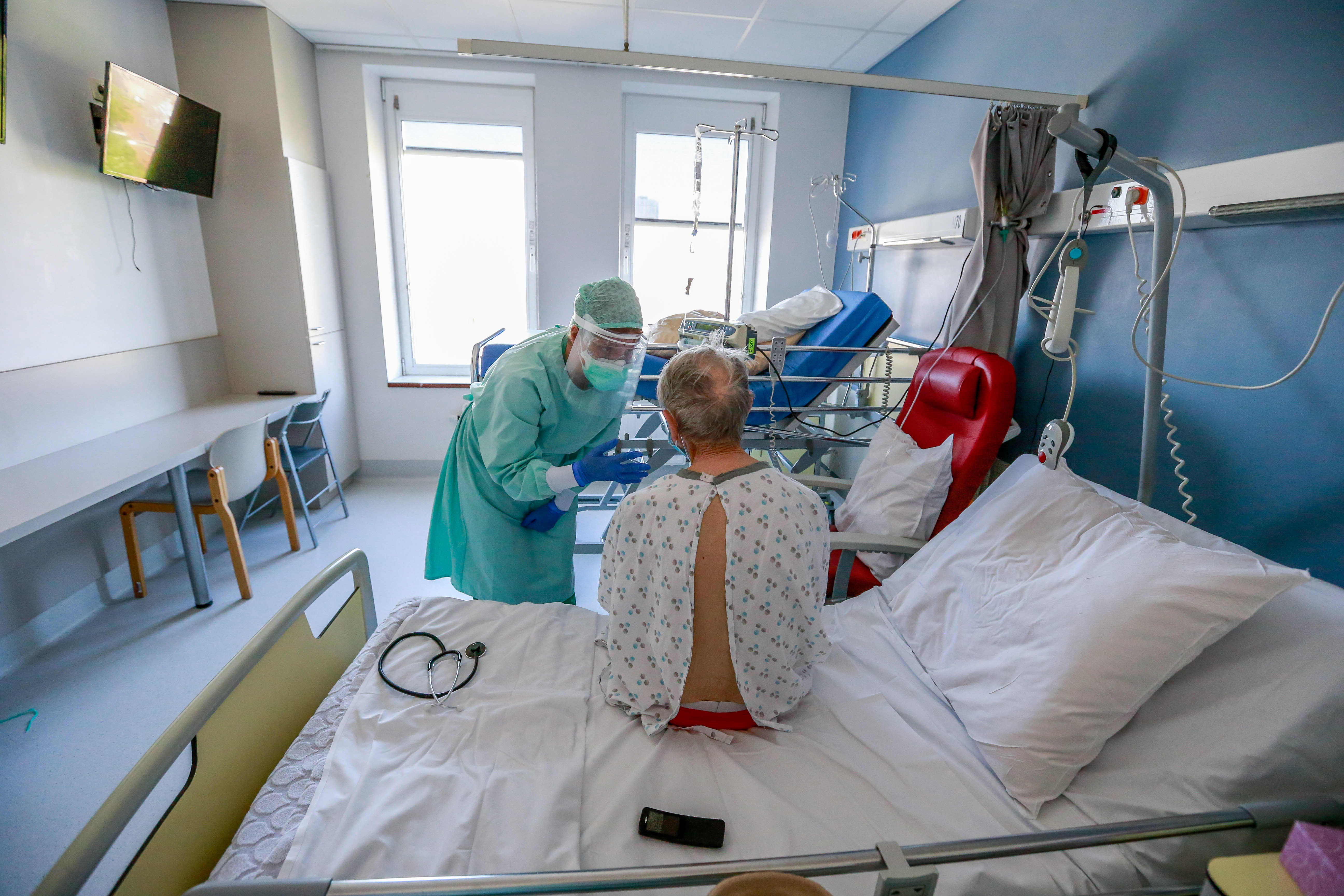 epa08385562 Anais, a doctor working in the COVID-19 unit, examines a patient potentially infected with the SARS-CoV-2 coronavirus at the Etterbeek-Ixelles site of the Iris Sud Hospitals in Brussels, Belgium, 26 April 2020.  EPA-EFE/STEPHANIE LECOCQ