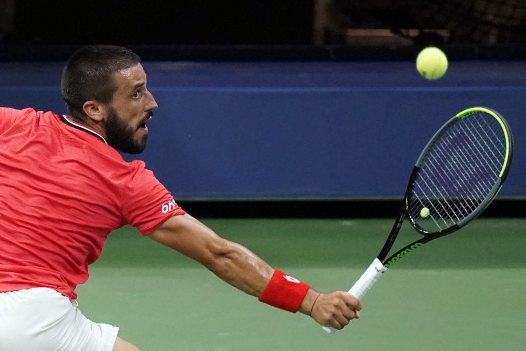 Damir Dzumhur, of Bosnia and Herzegovina, returns to Novak Djokovic, of Serbia, during the first round of the US Open tennis championships, Monday, Aug. 31, 2020, in New York. (AP Photo/Frank Franklin II)