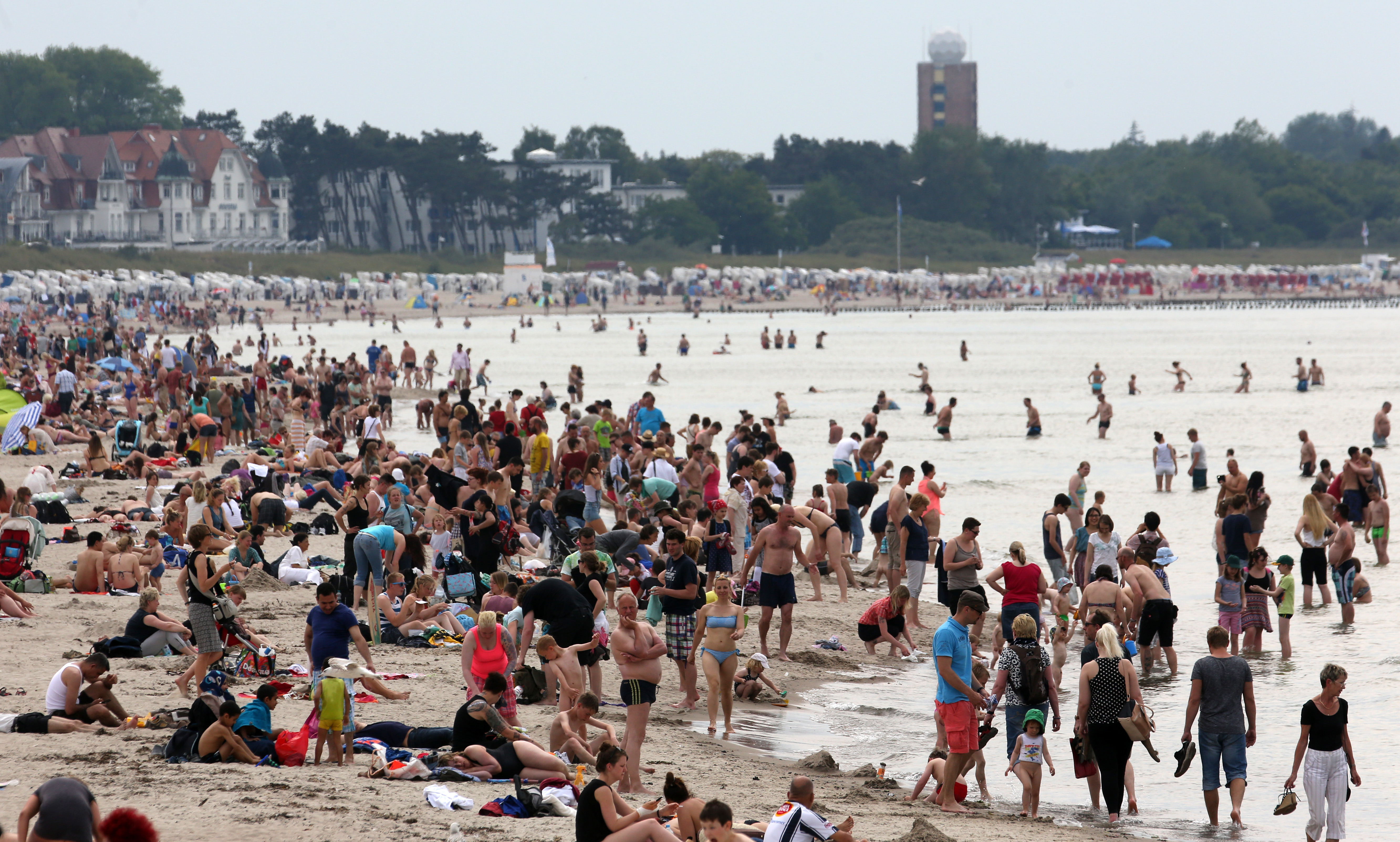 epa04797056 People crowd the beach at temperatures of 30 degrees Celcius in Rostock-Warnemuende, Germany, 13 June 2015.  EPA/BERND WUESTNECK