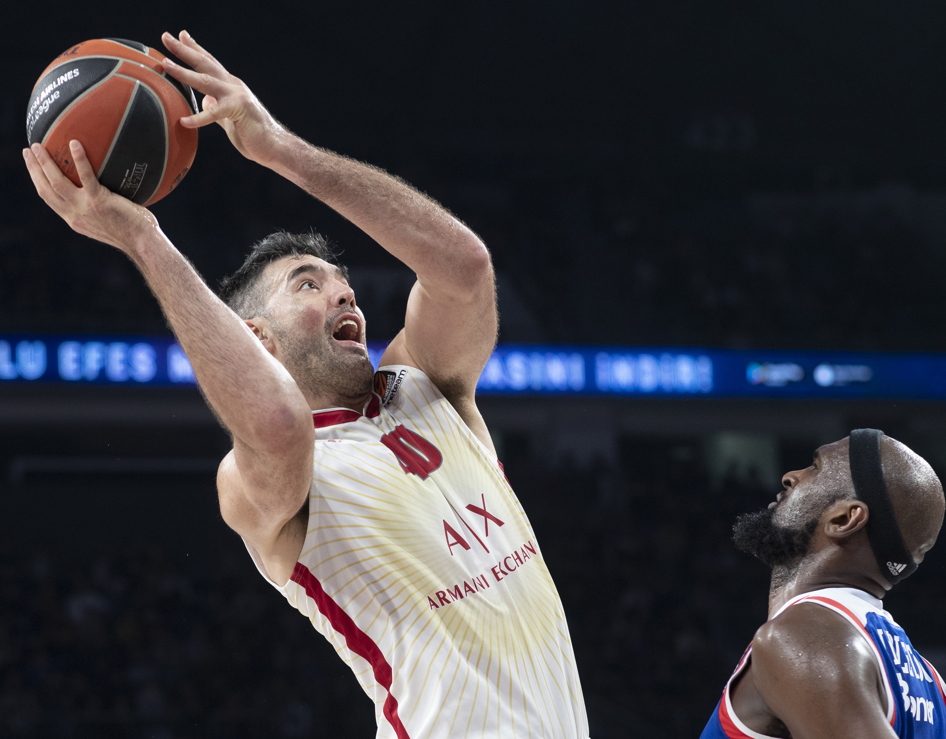 epa08128080 Ax Armani Exchange Milan's Luis Scola (L) in action against Anadolu Efes' Chris Singleton (R) during the Euroleague basketball match between Anadolu Efes and Ax Armani Exchange Milan in Istanbul, Turkey, 14 January 2020.  EPA-EFE/TOLGA BOZOGLU