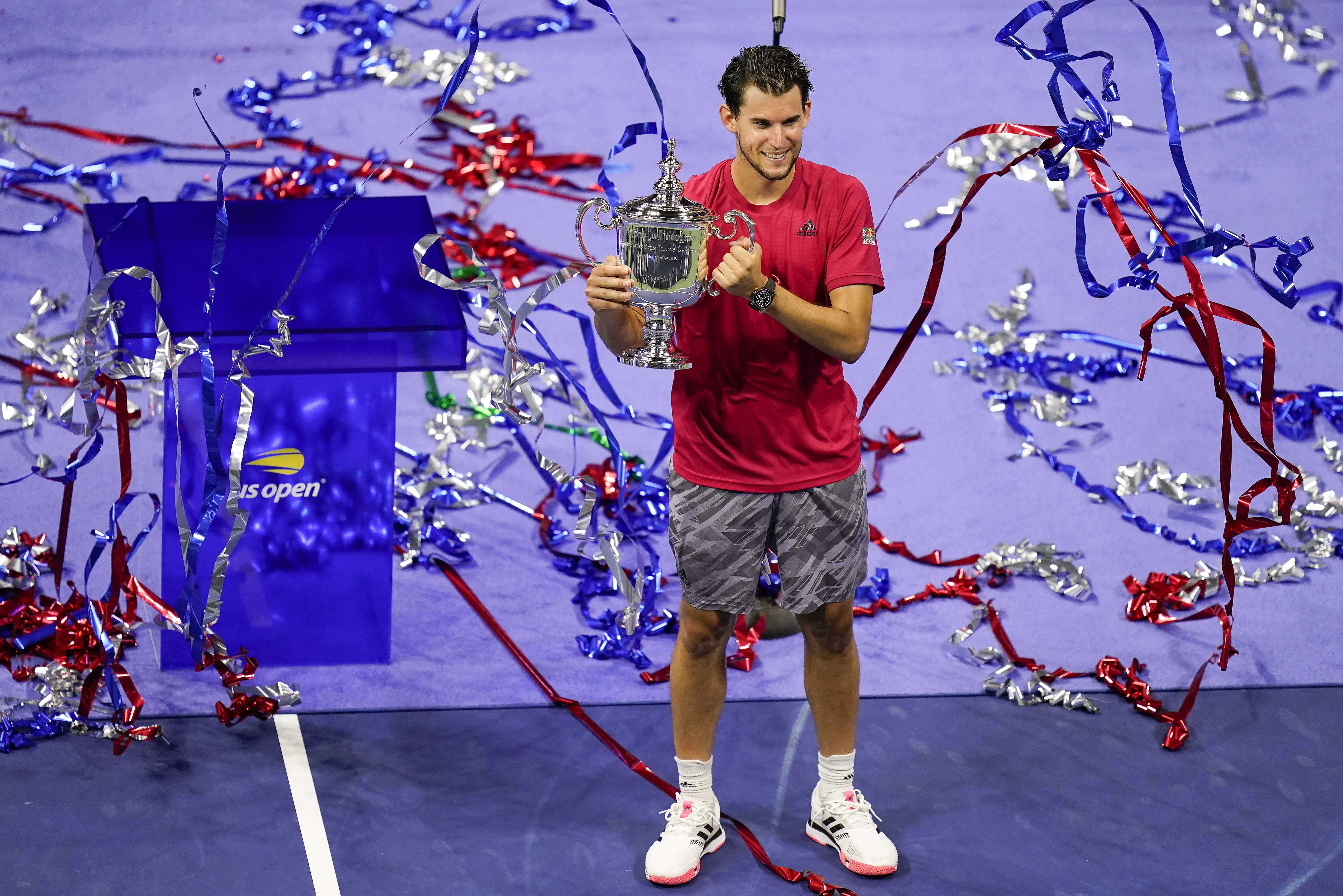 Confetti falls as Dominic Thiem, of Austria, holds up the championship trophy after defeating Alexander Zverev, of Germany, in the men's singles final of the US Open tennis championships, Sunday, Sept. 13, 2020, in New York. (AP Photo/Seth Wenig)
