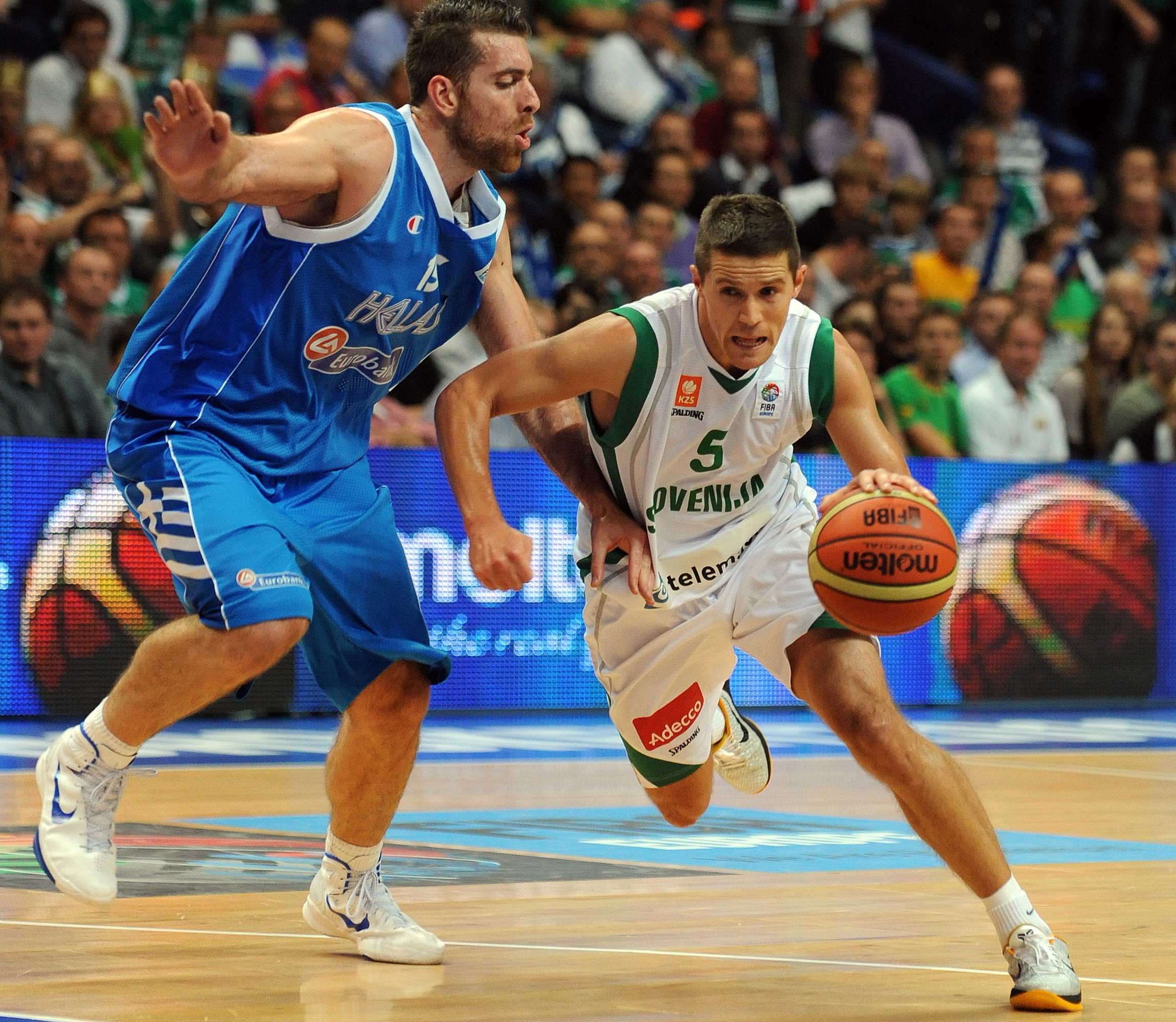 epa02904740 Slovenian Jaka Lakovic (R) tries to pass near Greek's Konstantinos Kaimakoglou during the second round match, group F between Slovenia and Greece at the EuroBasket 2011 in Vilnius, Lithuania, 08 September 2011.  EPA/GEORGI LICOVSKI