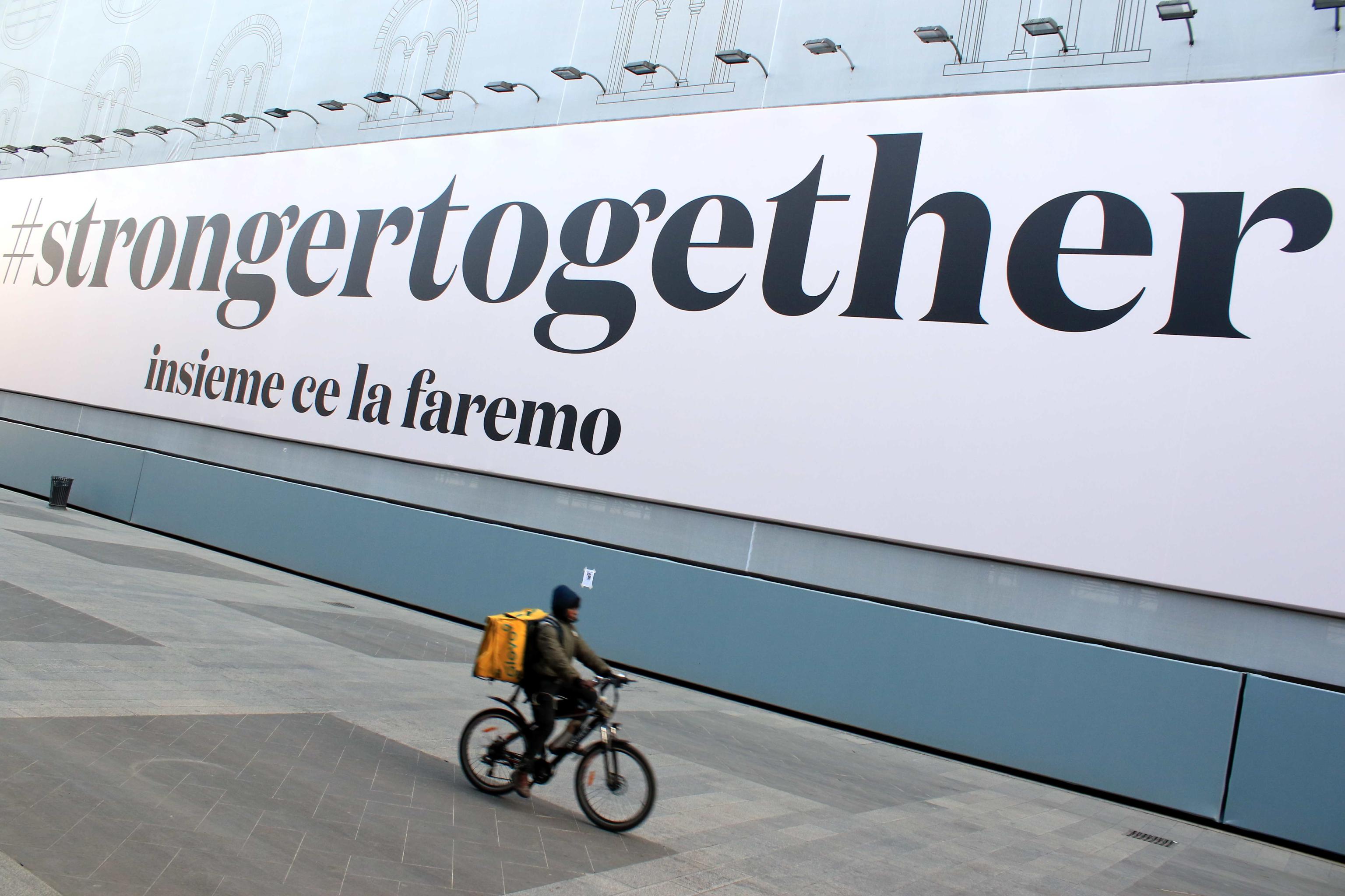 epa08316445 A sign that means: ''together we'll make it'' under ''strongertogether'' on the Lombardy Region Palace wall, Milan, Italy, 23 March 2020.  EPA-EFE/Paolo Salmoirago