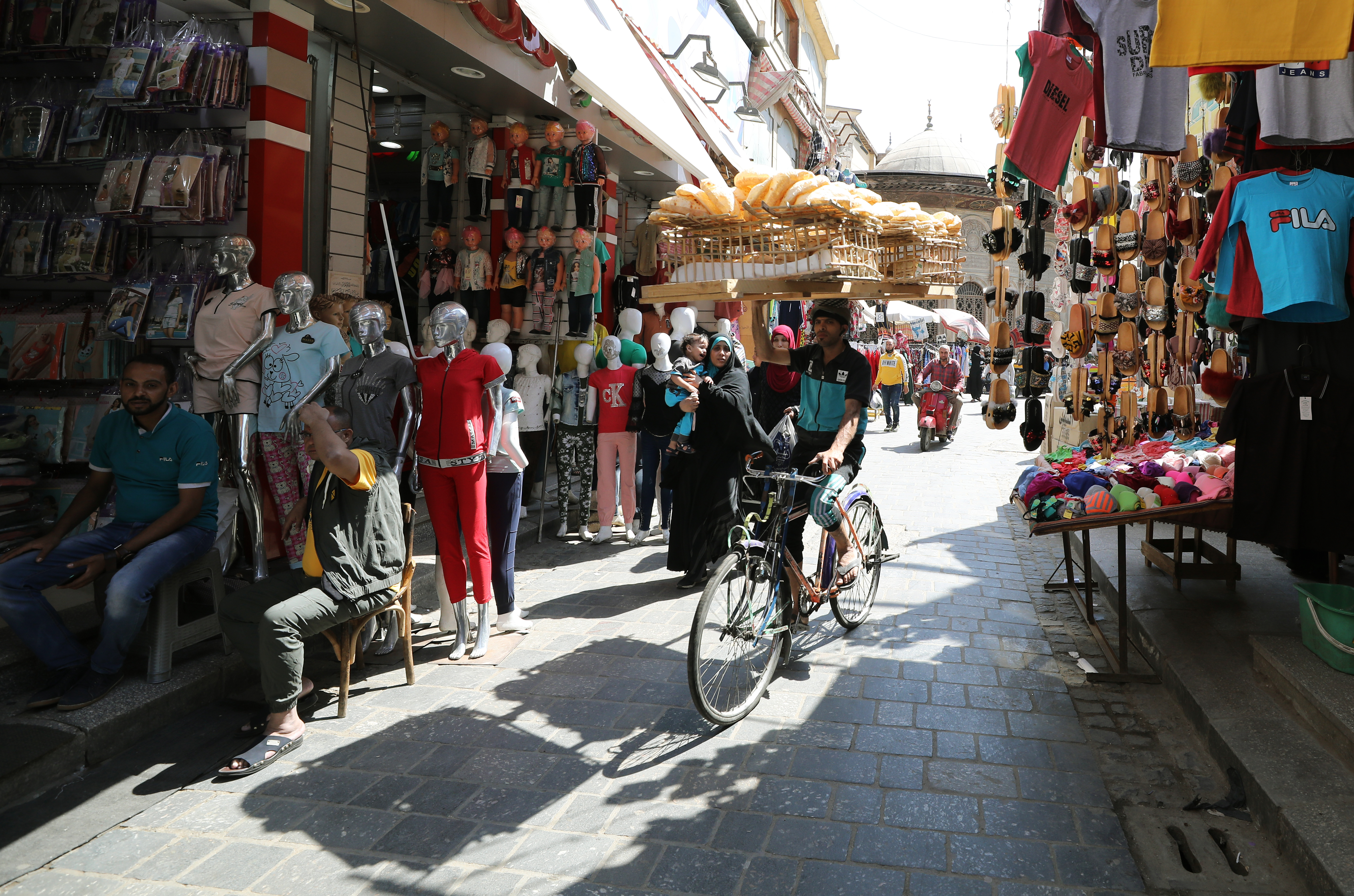 epa08405603 An Egyptian man carries a wood rack full of bread on a bike, in Bulaq neighborhood, Cairo, Egypt, 06 May 2020.  EPA-EFE/KHALED ELFIQI