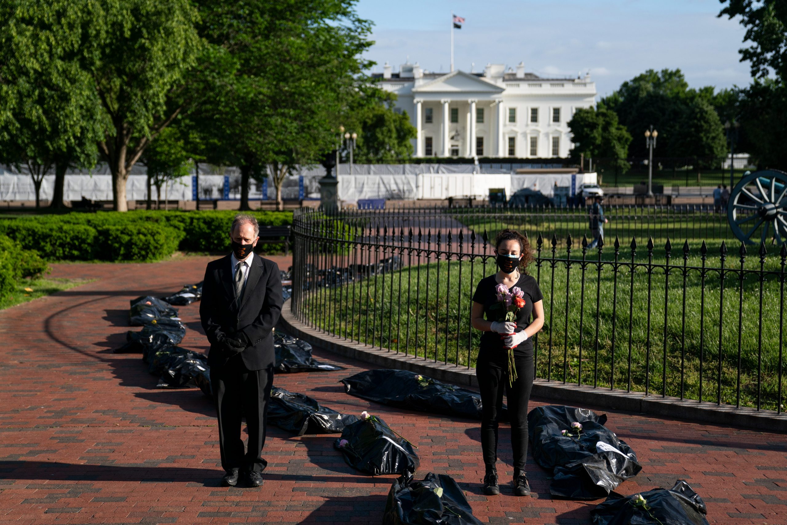 Michael Beer, of Arlington, Va., left, and Margot Bloch, of Takoma Park, Md., take part in a demonstration on the Trump administration response to the coronavirus pandemic, in front of the White House, Wednesday, May 20, 2020, in Washington.