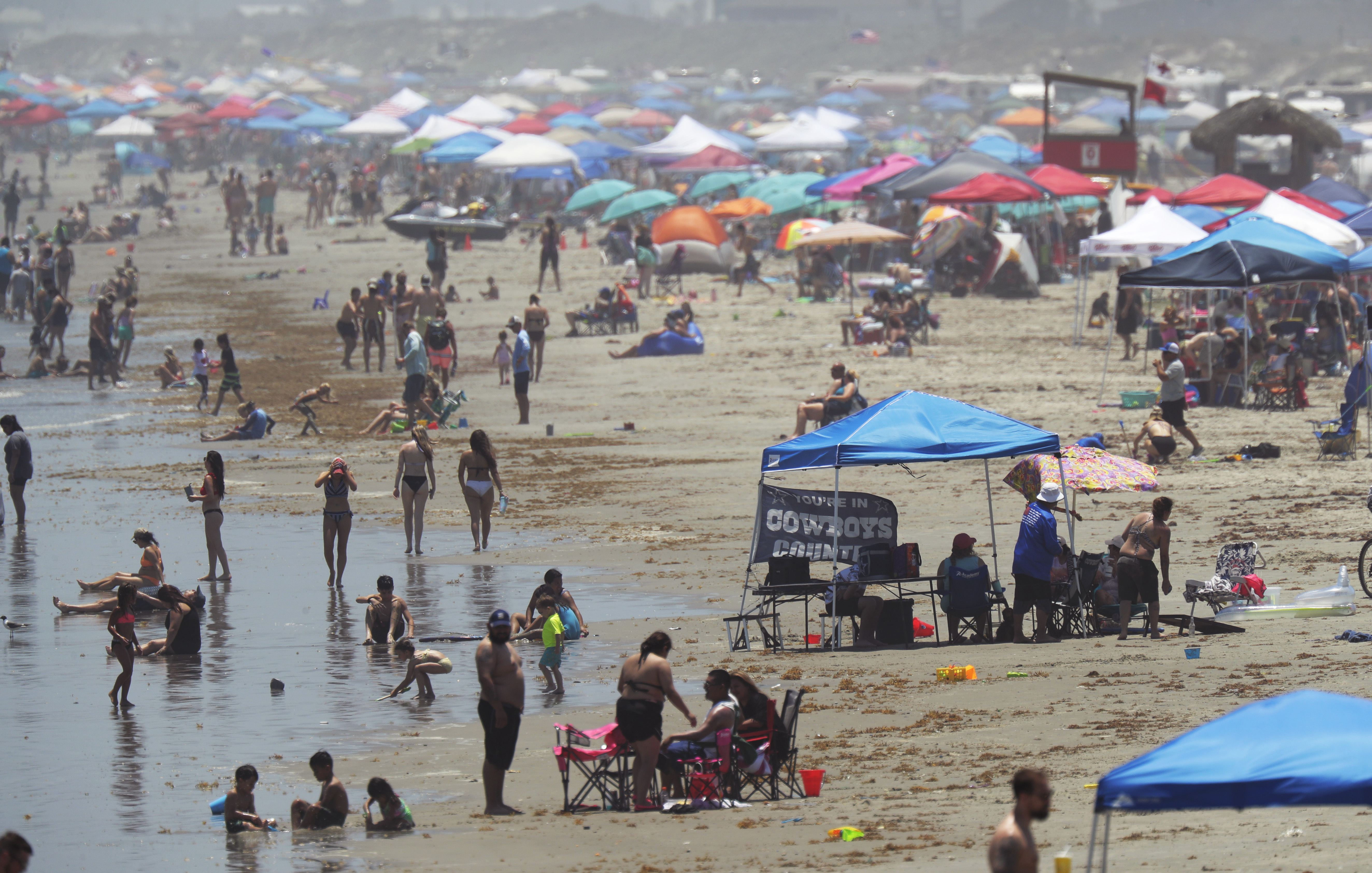 People gather on the beach for the Memorial Day weekend in Port Aransas, Texas, Saturday, May 23, 2020. Beachgoers are being urged to practice social distancing to guard against COVID-19. (AP Photo/Eric Gay)