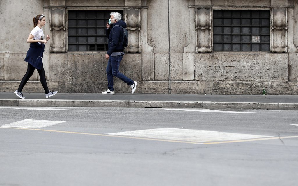 Otkaz epa08326713 A girl runs past a man wearing a protective face mask in via del Corso, Rome, Italy, 27 March 2020.  EPA-EFE/RICCARDO ANTIMIANI