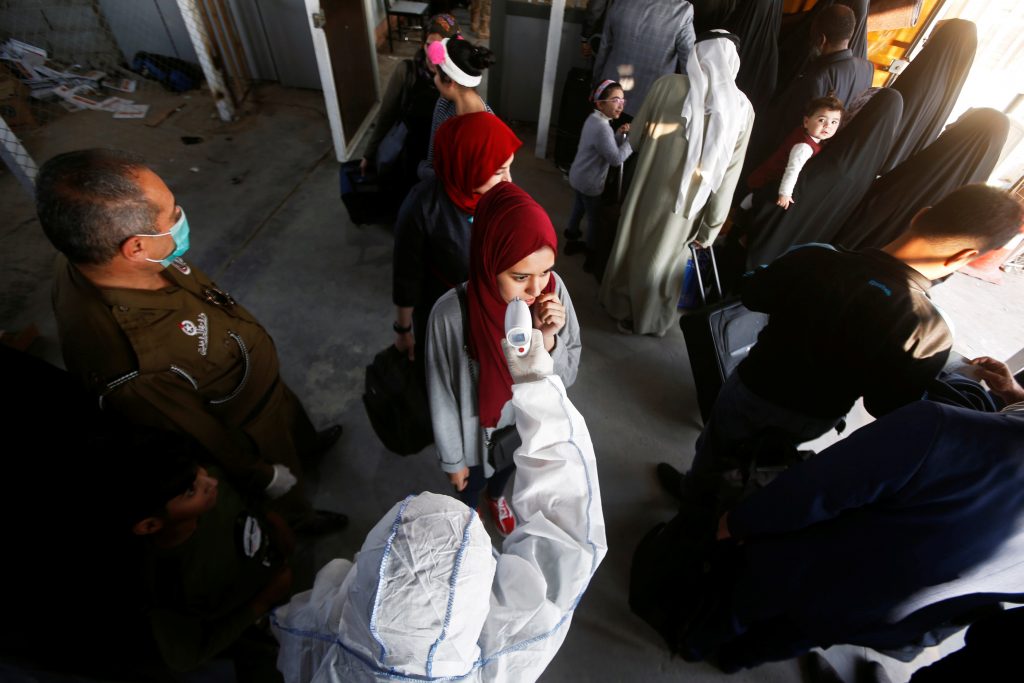 An Iraqi medical staff member checks a passenger's temperature, amid the new coronavirus outbreak, upon her arrival to Shalamcha Border Crossing between Iraq and Iran, February 20, 2020. REUTERS/Essam al-SudanI - RC2G4F90X06B