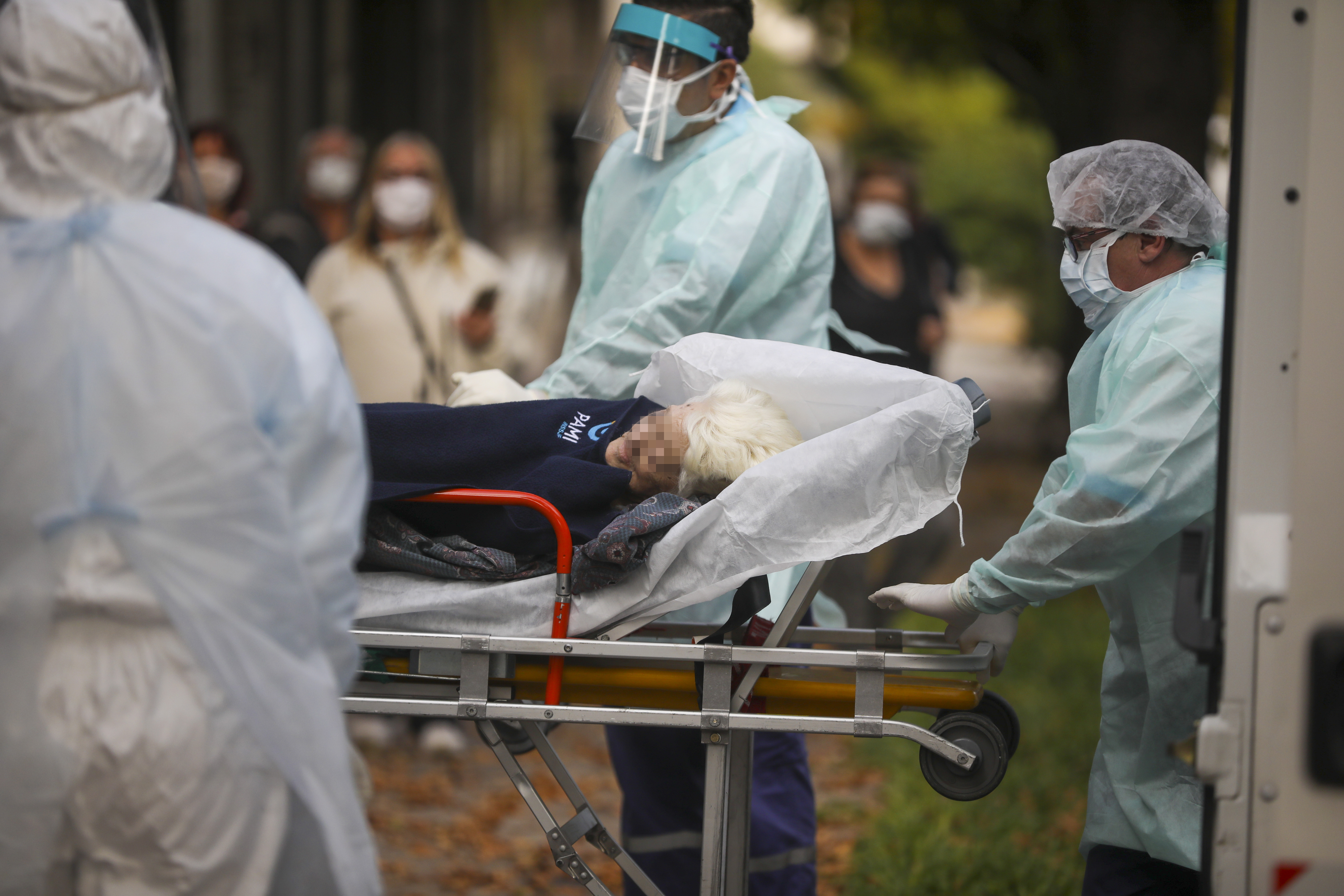 Medical staff evacuate an elderly woman from a nursing home after multiple residents of the facility tested positive for the new coronavirus in Buenos Aires, Argentina, Wednesday, April 22, 2020. (AP Photo/Natacha Pisarenko)