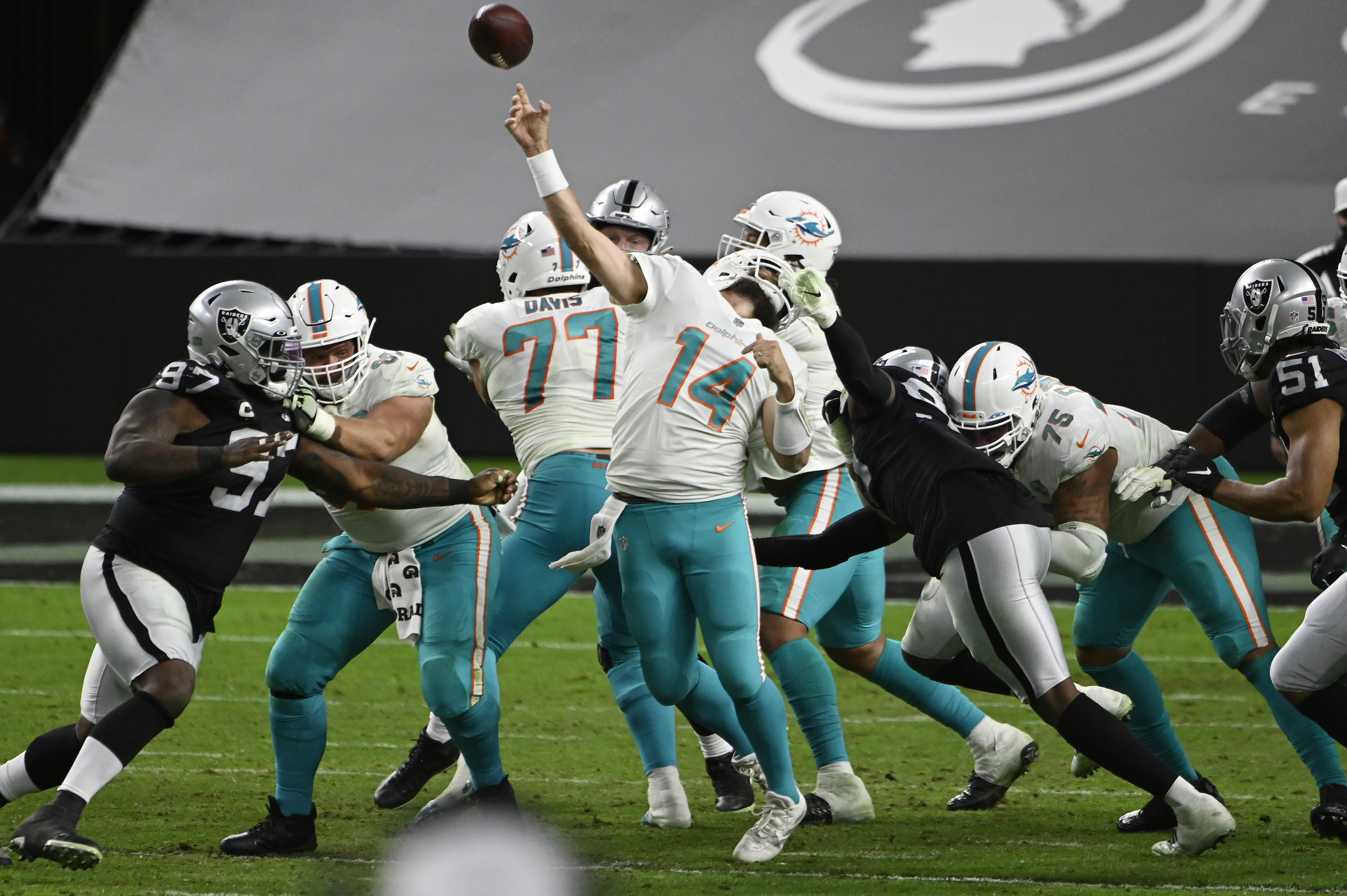 Las Vegas Raiders defensive end Arden Key (99) commits a roughing the passer penalty on Miami Dolphins quarterback Ryan Fitzpatrick (14) during the second half of an NFL football game, Saturday, Dec. 26, 2020, in Las Vegas. (AP Photo/David Becker)