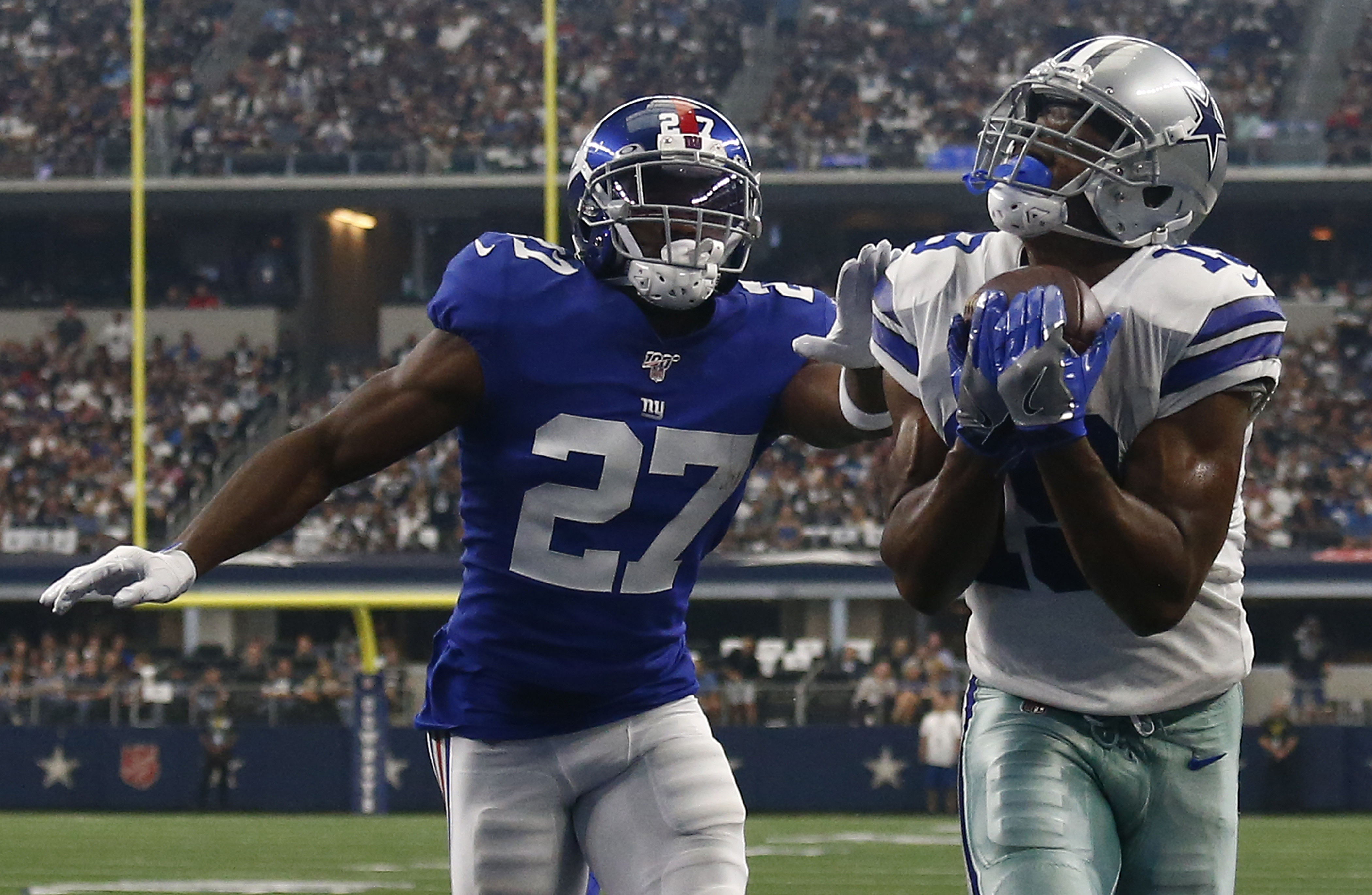 epa07828900 Dallas Cowboys player Amari Cooper (R) catches the ball for a touchdown against New York Giants player DeAndre Baker (L) in the first half of their game at AT&amp;T Stadium in Arlington, Texas, USA, 08 September 2019.  EPA-EFE/LARRY W. SMITH
